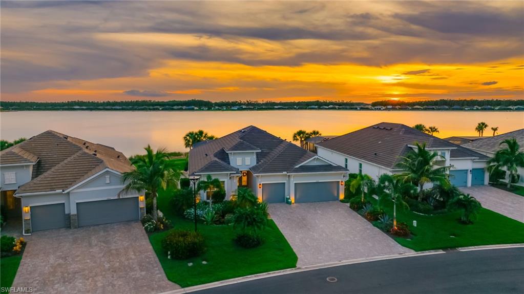 STUNNING SUNSET VIEWS! Shows like a model! Experience the pinnacle of waterfront living in this meticulously upgraded Summerville model, perfectly positioned on an oversize pie-shape lot for panoramic sunset views over the 300-acre boatable Lake Vista. Located within the gated resort community of WildBlue, this home shines with custom finishes and thoughtful high-end improvements at every turn.

Upon arrival, you're immediately greeted by colorful custom landscaping and double glass entry doors leading to the foyer and great room, highlighted by a spectacular built-in entertainment wall. The expansive kitchen features an extended island, a customized walk-in corner pantry, solid wood shaker style cabinetry with pull-out lower shelving, upgraded quartz countertops with matching backsplash, a natural gas cooktop, and built-in stainless steel appliances.

The master suite provides a luxurious and private retreat, separate from the other bedrooms, and bathed in natural light. Inside, you'll find a tray ceiling, sliding glass doors leading to the lanai, large windows, his and hers customized walk-in closets, separate dual vanities, and a glass-enclosed walk-in shower with dual shower heads and controls.

For true Florida-style living, the outdoor living area boasts a fully equipped outdoor kitchen, heated pool and spa, picture window screen cage, 8-foot extension for additional patio space, a porcelain tile pool deck, and custom retractable awnings for additional shade when desired. For peace of mind during storms, the home is equipped with impact windows and doors all the way around, a whole-home generator, and hurricane rolldown screens on the lanai.

Additional upgrades include plantation shutters on all windows, high-end light fixtures and fans, custom paint, crown molding and tall baseboards throughout, seamless glass shower enclosures, a whole-home water softener, a reverse osmosis filter in the kitchen, additional mini-split air conditioners in the master bedroom and garage, custom garage shelving, an exterior camera security system, and more.

WildBlue's amenity peninsula provides panoramic views of the nearly 600-acre WildBlue Lake, featuring a resort-style pool, separate lap pool, sandy lakeside beach, fitness center with studios, locker rooms with saunas, spa, a full-service restaurant and bar, poolside bar and grill, tennis and pickleball courts, a pro shop, basketball, boat ramps to over 800 acres of freshwater lakes, boat slip rentals, and more.

This is one you do not want to miss - schedule your private showing today.