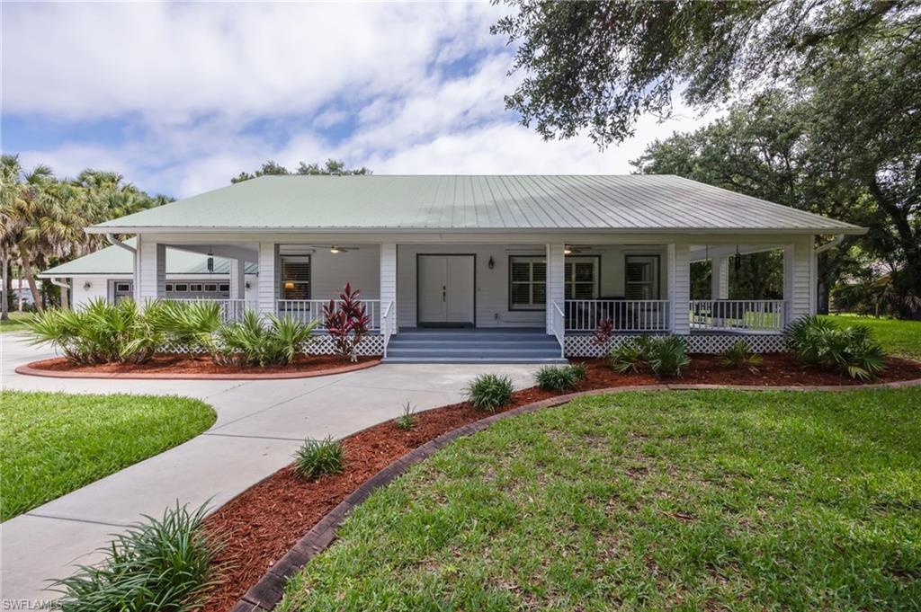 Welcome to your own private oasis! Cherished by its original owners, this meticulously maintained estate offers the perfect blend of country living and modern convenience. Situated on a rare, fully fenced and gated 2.5-acre lot west of Collier Boulevard, this property delivers unmatched privacy surrounded by a gorgeous, mature landscape of native oaks and cabbage palms. From the moment you arrive, the charm of this solid concrete block construction home is undeniable. Spend your mornings or quiet evenings on the oversized front porch swinging or simply relaxing. Inside, you’ll find a spacious and functional layout featuring 3 bedrooms plus a den and 2 bathrooms, highlighted by a beautifully remodeled kitchen (2017) that serves as the heart of the home. Step out back to your ultimate private retreat. The expansive rear lanai features a beautiful pool and spa with a desirable northern rear exposure, ideal for entertaining or unwinding in complete tranquility. For hobbyists, contractors, or equestrians, the exterior features are second to none: Massive Pole Barn: A 24’ wide x 36’ deep structure with a durable metal roof, set on a solid paver pad—perfect for boat, RV, or equipment storage. Equestrian Ready: 3 spacious 12x12 horse stalls fully equipped with heavy-duty stall mats. Homestead Addition: A custom 8’x6’x75” "hoop coop" design chicken coop, ready for your backyard flock. With major mechanical updates already taken care of—including a durable metal roof (2013) and an A/C system (2017)—this property is completely ready for its next chapter. Don't miss this incredibly rare opportunity to own acreage so close to everything Naples has to offer!
