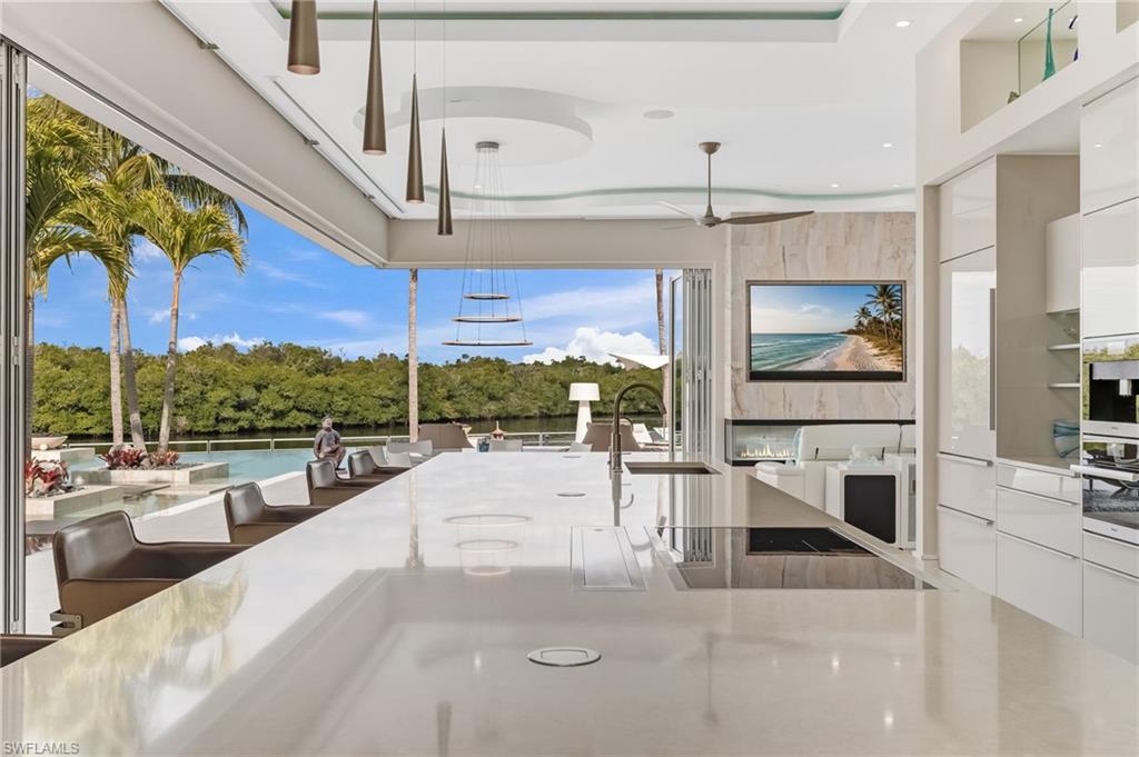 WITH THE ABILITY AND PLANS AVAILABLE TO ADD A FOURTH BEDROOM, this one-of-a-kind Fort Myers waterfront estate presents an exceptional opportunity to customize an already extraordinary residence. Bold contemporary architecture, uncompromising craftsmanship, and a true yachter’s lifestyle come together on nearly half an acre, with more than 7,600 total square feet and approximately 6,200 square feet under air.

Every detail has been carefully curated, from Italian porcelain flooring to custom Poggenpohl cabinetry carried seamlessly throughout the home. Lalique glass fixtures add an artful layer of elegance, creating a sophisticated atmosphere in every room.

Designed for the serious boater, the property features a 271-foot wraparound dock, two floating docks, a 40,000-pound boat lift, accommodations for an approximately 80-foot yacht, and direct Gulf access. Its position within a private, quiet, idle-speed zone provides calm waters and effortless departures.

The outdoor spaces transform the estate into a private resort. A spectacular entertainment deck, expansive gathering areas, and dramatic accordion impact-glass doors create a seamless connection between the interior and exterior living spaces. The showstopping zero-edge pool and spa, dedicated party room, and award-winning Crestron sound and lighting system make the home equally suited for grand entertaining and relaxed everyday living.

Inside, soaring 20-foot ceilings, luminous open spaces, and refined architectural details showcase contemporary design at its finest. The chef’s kitchen makes a statement in both style and performance with high-end Miele appliances, quartz countertops, and instant hot and cold water. A dramatic glass wine room and custom bar area, complemented by an alfresco gas grill, provide the perfect setting for unforgettable gatherings.

The thoughtfully designed floor plan prioritizes privacy. The primary suite, flex room, and gallery occupy the west wing, while the guest accommodations are positioned in the east wing. The primary bathroom offers a spa-like retreat with an oversized soaking tub, walk-in shower, heated towel rack, and television integrated into the mirror.

A rare five-car garage completes the property, providing abundant space for vehicles, recreational equipment, and storage. Conveniently located approximately 15 minutes from the private airport and 20 minutes from Southwest Florida International Airport, the home is also close to fine dining, shopping, and the area’s renowned beaches.

More than a residence, this remarkable waterfront estate is a private destination created for luxury living, effortless entertaining, and an unparalleled boating lifestyle.