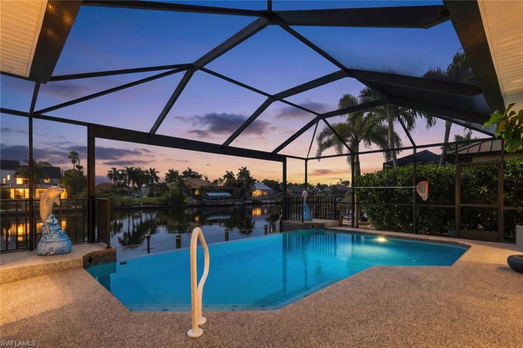 Live the ultimate Southwest Florida boating lifestyle in this beautifully updated Gulf access home in desirable SW Cape Coral. Situated on a wide canal, this waterfront retreat features a newer 10,000-pound boat lift with canopy, captain's walk, and Trex dock—perfect for effortless days on the water. Offering 4 bedrooms and 4 bathrooms, including 3 private en-suite bedrooms, the open-concept design is enhanced by soaring ceilings, tile flooring throughout, designer finishes, and impact-resistant windows that fill the home with natural light. The spacious kitchen boasts granite countertops, stainless steel appliances, abundant cabinetry, and opens seamlessly to the living areas, while a wet bar makes entertaining easy. Outside, enjoy a vanishing-edge heated pool, expansive covered lanai, and a generous pool deck overlooking the wide canal. Conveniently located near Cape Harbour Marina, waterfront dining, shopping, Sands Park, and Camelot Park, this exceptional home offers luxury waterfront living in one of SW Cape Coral's most desirable boating communities.
