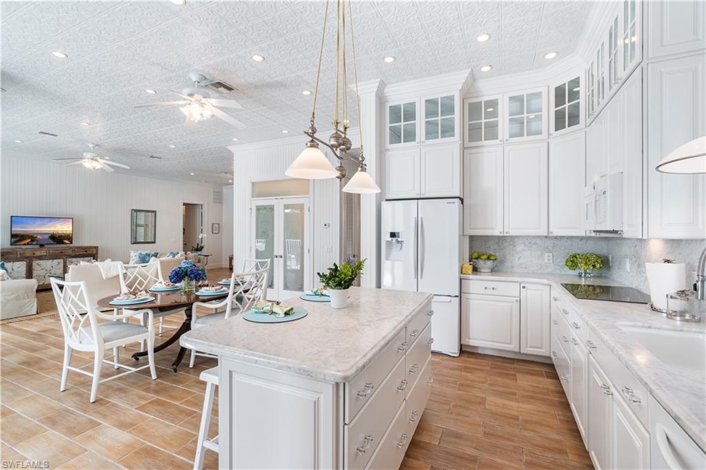This charming Key West-style beach home encapsulates the spirit of Old Naples living; it's nestled amid a beautiful mahogany tree-lined street only 1.5 blocks from the beach. Every detail in this custom home was carefully considered. Enjoy open and bright living with historic 12-foot tin ceilings with beadboard and detailed woodwork. Reminisce sitting on your rocking chair on the generous front porch or swinging on the swing on the covered back porch overlooking the sunny pool with preferred southern exposure. The home is handicap-accessible from the garage through the entire first-level to include the master suite and the den/office with an adjacent full bath. Your extended family is afforded privacy in the upper level with four large bedrooms, two full baths, and abundant storage. Above the garage, the two-bedroom apartment is perfect for a second office, workout space, or nanny quarters. The auto enthusiast three-car garage has a 240-volt charging station; a natural gas line is available. Take a short stroll or bike ride to the celebrated shopping and dining on renowned 5th Avenue South and enchanting 3rd Street South. Live, work and play by the beach.