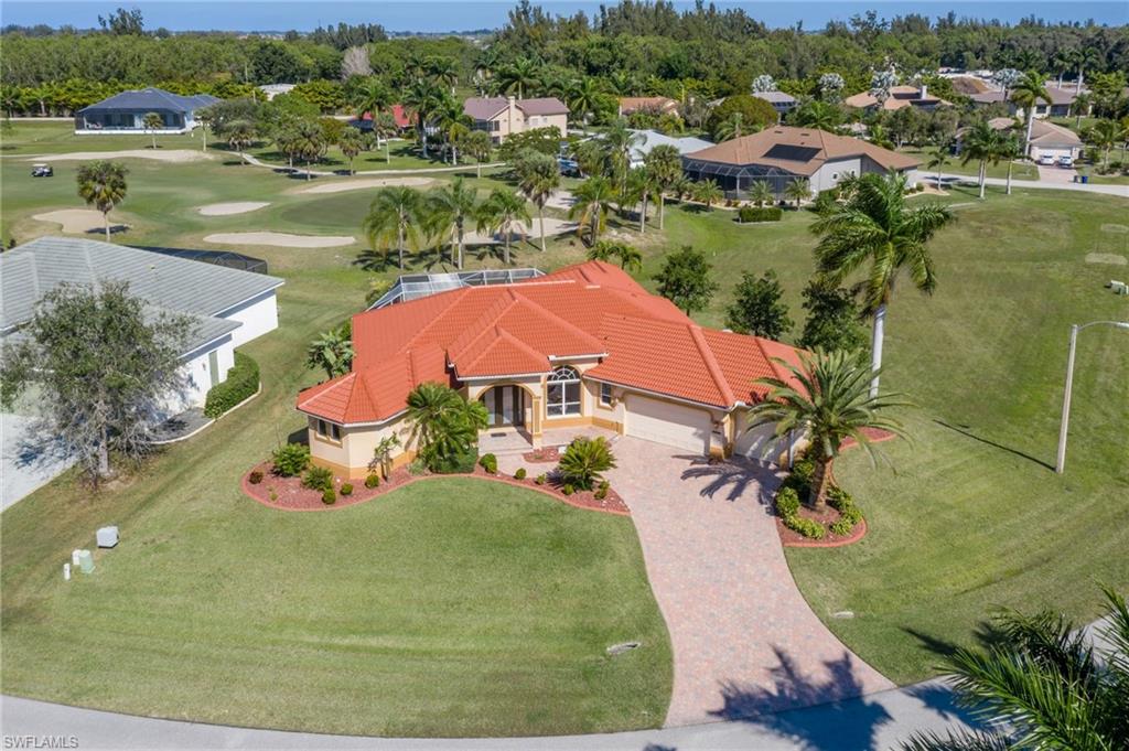This extraordinary Cape Royal home is sure to leave an indelible impression. So many quality custom upgrades to take in. With almost 3,000 square feet, 4 bedroom, 3 full baths, 15 foot volume ceilings and 3 car garage the overall effect is amazing! One of the finest kitchens you'll see features exquisite granite, big center island with sink, custom wood cabinetry, copper exhaust hood, gas range, double ovens, Kitchen Aid stainless appliances, pot filler faucet, tumbled stone backsplash, wine cooler. Built-in wood entertainment center in living room. Enormous master suite large enough to set up a home office within. Master bath offers luxurious jetted tub, walk-thru shower, double sinks, 2 walk-in closets. Tile throughout entire home! Unique custom ceiling fans and light fixtures in every room. Large pavered lanai and pool deck. Beautiful pool with spill-over spa and fountain looks out to pleasant golf course views. Cape Royal is a gated, financially strong community without all the fees, Pine Island public water and it's located in Lee County(not Cape Coral) means LOWER TAXES.