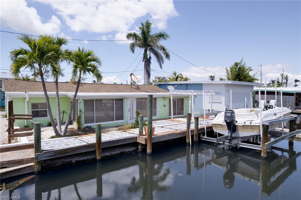 Discover your slice of paradise in the quiet fishing town of Matlacha Island. This charming 2 bedroom 1 bath home offers the perfect blend of island character and modern comforts. This home is a boaters dream with direct access with wood dock and boat lift out back along with a kayak rack for those AirBNB guest or avid fishermen. Step inside to an open & split floor plan with plenty of light. Newer roof, New cabinets and A/C with tile flooring throughout. Whether you're looking for a full time residence, vacation getaway, or investment opportunity, this Matlacha waterfront gem!! Nestled in prime location and walking distance to shopping, art galleries and restaurants, and just a short drive to Cape Coral & Fort Myers, this is a true old Florida Living with modern day convenience.