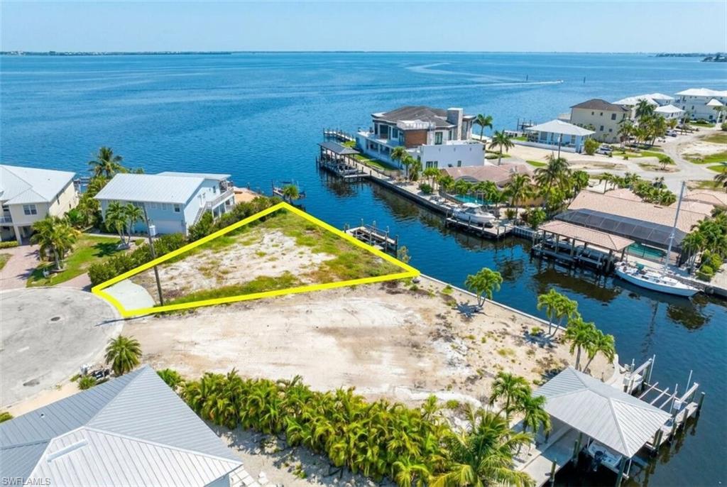 One or more photo(s) has been virtually staged, AI generated or rendered.  BOATERS DREAM LOCATION. Relax and enjoy Endless PANORAMIC BAY views  from this extraordinary Oversized Gulf Access Canal parcel with 112' of Seawall. Amazing NEW CONSTRUCTION opportunity, perfectly positioned on a Gulf-access homesite at the end of a quiet cul-de-sac, this RARE property captures stunning water vistas across Estero Bay while offering the ultimate island lifestyle with direct beach access just moments away.

Optional assemblage opportunity with 18 & 20 Avenida Carita; purchase separately or together to create an exceptional waterfront compound totaling approximately .37 acres. These oversized canal-front lots offer unparalleled flexibility for a grand estate, guest residence, or multiple homes.

18 Avenida Carita features a boat lift, private dock, and a grandfathered waterfront structure with a metal roof, adding unique character and flexibility rarely found on island properties. The covered boat lift is complemented by an additional open-air lift with dedicated space for both a boat and personal watercraft. 20 Avenida Carita offers its own separate boat lift and dock, providing extensive dockage for multiple vessels and an unparalleled waterfront experience.

Whether enjoying morning coffee overlooking the water, watching dolphins play in the bay, or taking in the vibrant evening sunsets, the setting is truly exceptional. This premier boating location provides quick and convenient access to open waters, making it a dream destination for boating enthusiasts and waterfront lovers alike. The generous parcel provides ample room for a custom estate home, resort-style pool, outdoor living spaces, and extensive dockage, creating the perfect private coastal retreat.

Multiple builder introductions are available, and a survey is available upon request. Whether you're seeking a luxury waterfront residence, a family compound, or a legacy island estate, this one-of-a-kind property presents a rare opportunity to build around some of the most captivating bay views and boating access Southwest Florida has to offer.