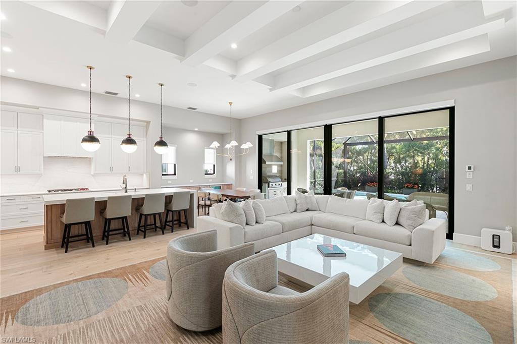 Exquisite home custom-built by award-winning London Bay Homes in secluded yet convenient Cambridge Park at Orange Blossom. This coastal contemporary, one-story smart home with great room floor plan and high ceilings has incorporated every imaginable upgrade including custom lighting, gorgeous Italian oak hardwood flooring, cozy fireplace, electronic shades, upgraded televisions with sound bars and surround sound, Wolf and Sub-Zero appliances, outdoor lanai and summer kitchen with outdoor television, upgraded Nassau pool with spillover spa, custom millwork, air-conditioned garage and whole-house generator. This one-story, low-maintenance home is offered with furnishings negotiable, ready to move right in and enjoy. Landscaping and pool maintenance are included in the reasonable HOA fees, enabling residents to enjoy the ease of condominium living with the privacy of a single-family home. Just minutes from Naples sparkling white sand beaches, both Ritz-Carlton resorts, and Mercato and Waterside Shops.