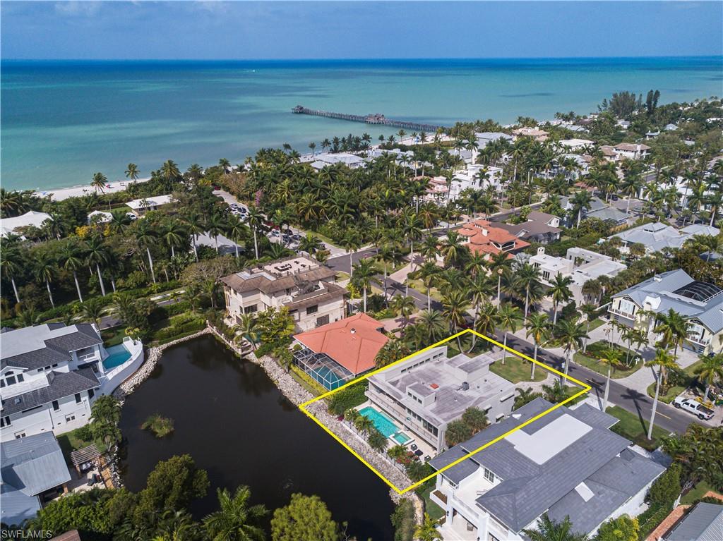 LOCATION - LOCATION - LOCATION. 4 years young, stunning, contemporary beach home. Best price in the Aqualane Shores neighborhood. 1.5 blocks to beach and 3rd Street. ABSENTEE OWNERS AND/OR INVESTORS PAY ATTENTION: Can be rented during high season for $20,000 + per month. The kitchen is state of the art (with natural gas). Top brand appliances and open to the dining and living area. Gas fireplace in the living room and stunning wood floors throughout. Backyard offers oversized pool and spa. Tremendous entertainment area with pool-side covered bonus room. Elevator for your convenience. Outdoor dining with lake view from large deck and master bedroom. This home is located on one of the small lakes in Aqualane Shores which is owned by the home owners and not the City of Naples. With three over-sized garages and two driveways, there is plenty of room for multiple vehicles. Lots of storage with hobby room on the ground floor. This property is A MUST SEE.