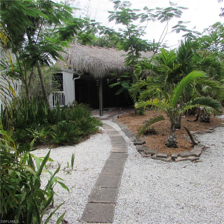 A Dream Historic property... 7.5 Acres in Bokeelia Built in 1949 a wood frame 2/2 classic Island house, wood floors in Excellent condition.. Check out the Tiki deck area around the house.. New Metal Barn (20' x 40' with a 13' x 40' lean-to) for tractor, storage and Stalls for Horse or Llamas  !! second barn with stalls, Work shop, fenced animal pastures,  Mango Grove with many varieties, Lychees, hundreds of bromeliads and heliconia's, huge sausage Tree, beautiful pond ... this is a botanical Garden, 77 years in the making, ready for you to plant more and continue this tropical tradition... There is a 2.5 acre tract attached that you could add to this property...TAKE A LOOK AT THIS TROPICAL PARIDASE TODAY !!!