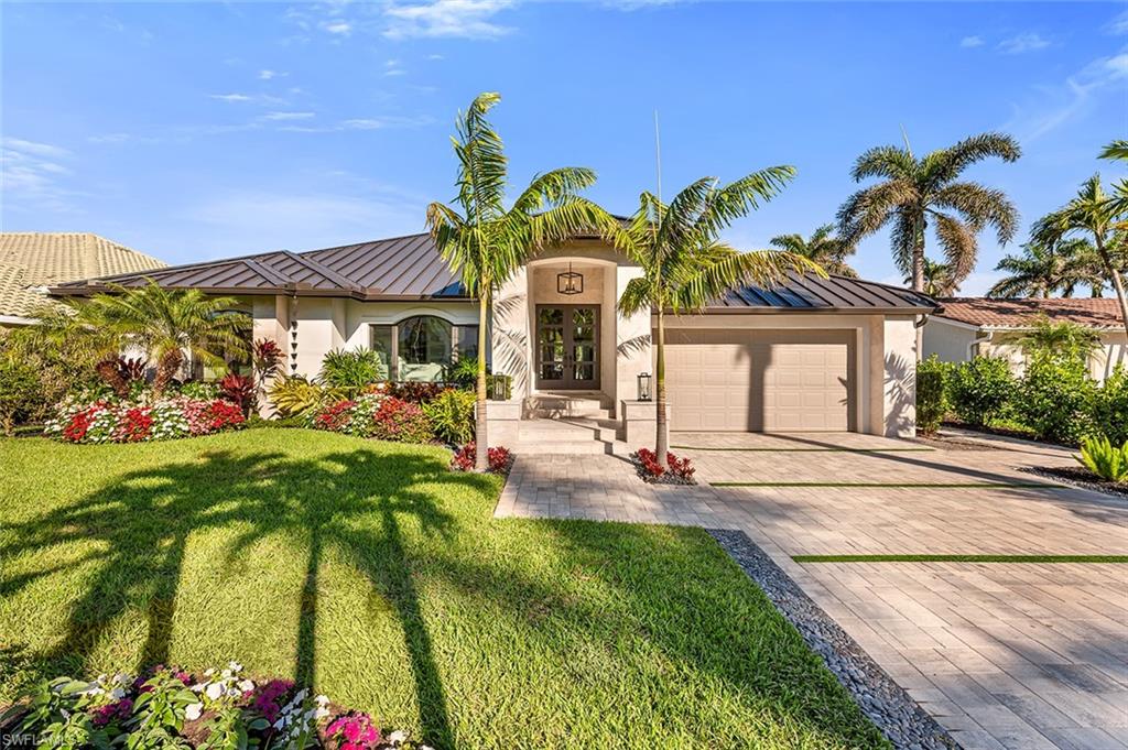 This exceptional custom waterfront home boasts 80’ of water frontage in highly desirable southern Royal Harbor. Fully renovated in 2024, it features a new in-ground jacuzzi, updated pool and waterline tile, new aluminum roof, new driveway and pool patio pavers, impact-resistant doors and windows, Azenco pergola with motorized louvers and LED lights, motorized hurricane screens, and a new gas cooktop and BBQ grill. Freshly painted, upgraded bedroom entries, primary bath renovation, new wood flooring, and new countertops are just a few of the highlights. The property offers an attractive open floor plan with split bedrooms, high ceilings, and numerous windows and custom mirrors that fill the space with natural light. The new dock is equipped with a 20,000 lb. boat lift. The home showcases many modern upgrades, custom floating shelves, and stylish finishes throughout. The covered outdoor living area is designed for entertaining, with an outdoor kitchen and living space. The inviting pool with sun shelf provides a relaxing spot to lounge. Conveniently located just minutes from the dining, shopping, and pristine beaches of 5th Avenue South and 3rd Street South. Take your street legal golf cart to dinner.