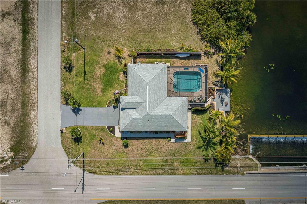 WHAT reduced to $500,000...this won't last long! LOOK AT THIS HUGH HEATED POOL, SPARKLING BEAUTIFUL CANAL!!! The Spectacular Home offers it ALL. ROOF is only 5 yrs old! As you enter, a gorgeous Tiled Mosaic greets you. You notice how Bright and Open the home is. The Great Living room opens onto an Impressive and Large Kitchen with Lots of Cabinets and Stunning Quartz Counter Tops. Even the Coffee Bar has the same Attractive Tiled Backsplash. Nice Stainless Appliances and so Much Room. The Dining Areas view of the Pool and Canal is Remarkable. The Main Bedroom is Huge and opens out to the Impressive Entertaining Outdoor Living and Entertaining Area. Main Bathroom has a Stunning Double Sink and an Exceptionally Tiled Shower. The 2nd Bedroom is as large as the Main and has a View to Die For! The 3rd bedroom is also Good Size and shares a Bath that Leads Directly out to the Pool. Now let's venture outside..Start by Entertaining on this Large Covered Lanai then Jump into the Massive Heated Pool that is so Inviting and Refreshing. More you ask…? Your New Home comes with an Oversized Dock and sets on one of the Best Fresh Water Canals in Cape Coral. Access to Many Lakes and EVEN a Waterfall Spill-Way to enjoy and listen to.  Hurry…