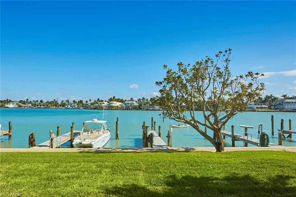Welcome to your slice of paradise in Naples! This renovated, first-floor sanctuary is a coastal haven with captivating features. Sweeping bay views greet you when you step into this two-bedroom, two-bath corner unit. Watch the morning sunrise, marine life, and boaters heading to the gulf from your private waterfront retreat. For the boating enthusiast, slips may be leased through the management association with direct gulf access with no bridges. The recently refurbished Spindrift Club boasts a new pool and pool deck, a chic lobby with secure entry, covered carports, poolside grills and part-time manager. Lush landscaping envelops the grounds, creating a tropical oasis. Cross Gulf Shore Boulevard to the pristine, white-sand beaches for leisurely strolls or sunset spectacles. Indulge in the convenience of dining and boutique shopping at Venetian Village, Waterside, and 5th Avenue, all just moments away. This property is more than a home, it's an invitation to a lifestyle where every day feels like a vacation. Don't miss the chance to own a piece of Naples' desired Gulf Shore Boulevard in the Moorings where each day is a celebration of sun, sea and sophisticated living.