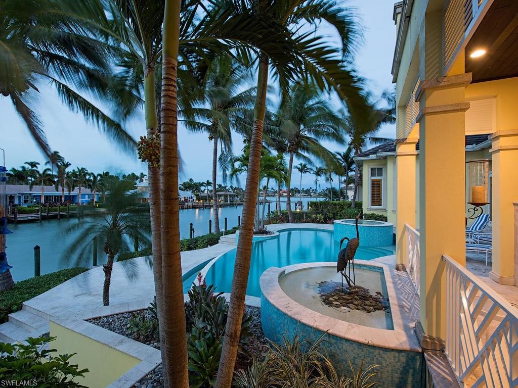 H.12904  2 story Bermuda style home situated on Jamaica Channel with a view of Naples Bay.  The 90' dock plus 45' boat slip places you on a deep water canal with direct access to the Gulf of Mexico.  Lots of room for toys in the over-sized 3 bay garage.  Constructed in 2009 and improved with tile/marble flooring in main living areas, wood flooring and carpet in bedrooms, granite counter tops, tray ceilings, crown molding, gas fireplace and range, wet bar with wine cooler, lanai grill and fireplace, 2nd floor balconies, electric and gas heated pool and spa. This waterfront property is available now to start "Living your Dream."