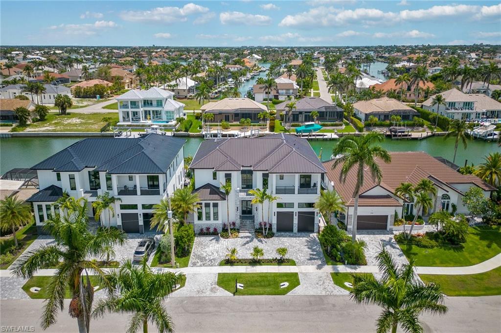 This 2022-built estate has everything one needs to enjoy all the benefits of waterfront living and the barefoot luxury lifestyle. Offering nearly 4,400 air-conditioned square feet over two floors with five bedrooms, den, five full and two half baths. The coastal-chic, open-plan design offers a clean, crisp and comfortable space that flows naturally into the outdoor living spaces which are ideal for entertaining and taking in the beautiful setting. Throughout, you can enjoy multiple terraces, each offering its own relaxation space. The open lanai has a large, covered space with summer kitchen, heated pool with sun-shelf and spa that overlook your beautiful docking facility with two lifts. Quick, direct access out to the Gulf and 10,000 Islands. Over $150,000 in upgrades: elevator, generator, impact glass, Sonos entertainment, Kinetico water filtration system, AC garage, commercial water heaters, Sunshade patio bug screen, programmable home lighting, Lutron lighting main common areas, security cameras to name a few. A must see to appreciate this beautiful residence on the desirable south-end and is within one mile of Marco Island’s “South Beach,” many restaurants, shops and more.