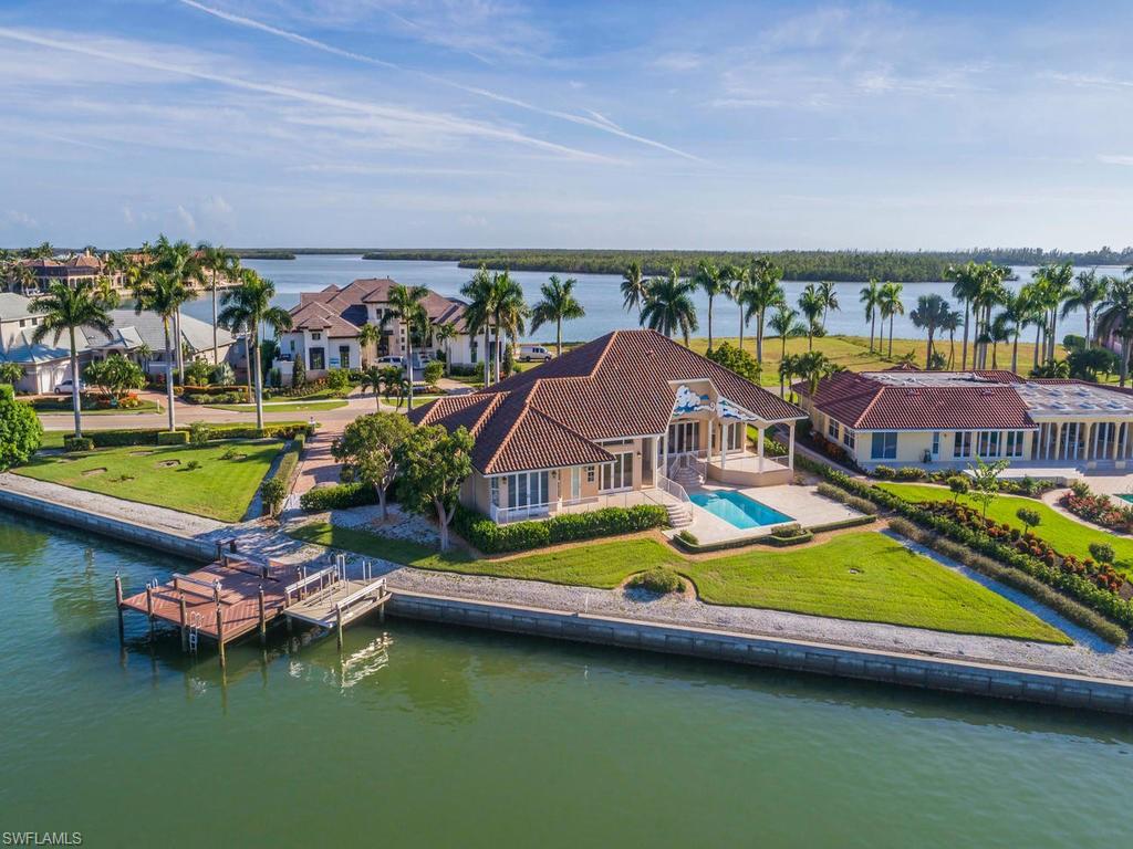 H.13786 - This British West Indies Style masterpiece home boasts the largest water frontage in the exclusive enclave of Caxambas Island. Casual, elegant home boasts spectacular views, sunsets over the bay, quick direct access to the Gulf of Mexico, and palatial outdoor entertaining areas. Upon entry you are captivated by the open and expansive bay views and entranced by the coastal decorating in the living room & dining room which features electric shades for privacy, the light and bright decorating, and gas fireplace. The master bedroom has distinctive bead-board accent in the tray ceiling, porcelain wood flooring featuring, stunning bay views. The three guest bedrooms and den (decorated as fourth bedroom) all offer an en-suite experience & elegant, coastal decorating for your guests. The kitchen, breakfast nook, and family room all overlook the stunning bay views.  The gourmet kitchen offers glass tile back splash, granite counter tops, accent lighting, and high-end appliances. Enjoy entertainment in the theater room. Don’t miss the chance to own this boaters delight with over 350’ of water frontage, located on one of Marco Island’s most prestigious addresses, Caxambas Island!