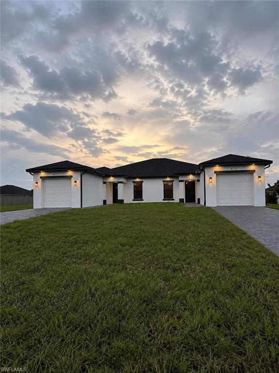 Welcome to this stunning brand-new duplex in Lehigh Acres — a rare opportunity for investors or owner-occupants seeking premium construction and modern design. Each identical mirror-image unit offers 3 bedrooms, 2 baths, and 1-car garage across 1,169 SF of air-conditioned living space, totaling 3,104 SF under roof. The den has been converted into a third bedroom, maximizing living space and rental income potential.
Curb appeal impresses from the moment you arrive — crisp white CBS construction with bold black trim accents, illuminated soffit downlights, decorative wall sconces, and dual paver driveways create a striking contemporary facade. The lateral entry design provides each unit with a private, covered approach, adding privacy and a sense of arrival that tenants and owners alike will appreciate.
Inside, every inch reflects quality craftsmanship. Gleaming large-format polished porcelain tile flows throughout all living areas. The open-concept kitchen and great room are flooded with natural light through impact-resistant black-framed windows. Each kitchen features floor-to-ceiling upper cabinets in a warm wood-tone finish, dramatic calacatta gold quartz countertops and backsplash, a deep undermount sink with commercial-style pull-down faucet, a large quartz island with waterfall edge, and a full stainless steel appliance package including refrigerator, range, microwave, and dishwasher. Recessed LED lighting throughout keeps the spaces bright and modern.
The master bath is a true showstopper — floor-to-ceiling dramatic black marble-look porcelain tile, frameless glass walk-in shower with rain head and built-in niche, hexagonal mosaic tile shower floor, LED recessed lighting, and an LED-backlit vanity mirror. The guest bath is equally refined with frameless glass shower enclosure, polished marble-look tile, quartz vanity top, chrome waterfall faucet, and LED mirror.
The spacious walk-in closet features wire shelving systems and dedicated recessed lighting. The laundry room is upgraded with a dedicated utility sink vanity finished in matching quartz countertop and wood-tone cabinetry — a feature rarely found at this price point. All bedrooms include ceiling fans with light kits and recessed lighting.
Step outside to the private covered lanai finished with large-format porcelain tile, ceiling fan, and recessed lighting — perfect for year-round outdoor living in true Florida style. Each garage is finished with a full epoxy-flake floor coating, automatic opener, and electrical panel.
Built to 2023 Florida Building Code with 160 MPH wind-rated impact windows and doors throughout. Both units are separately metered and fully self-contained — ideal for a live-in rental strategy or pure investment. Property is currently awaiting Certificate of Occupancy (CO). Buyer to verify timeline with seller prior to closing