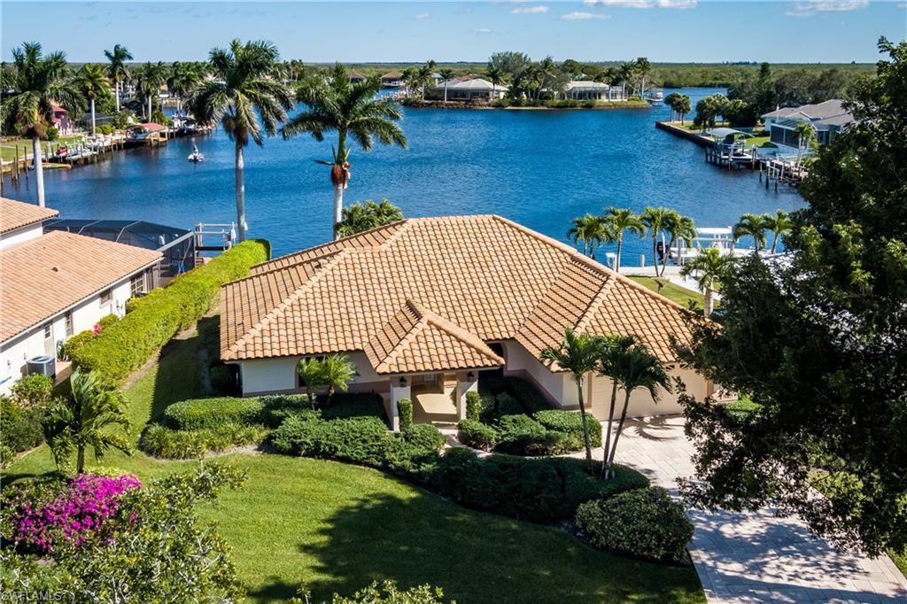 BIG BAY VIEWS from this great room design 3 bedroom, 2 bathroom, 2 car garage home located in the fishing and boating community of Port of the Islands.  The home offers a galley kitchen and breakfast nook, oversized garage, utility room. enclosed lanai for entertaining, and a dock with lift and extra storage.   Accordion shutters were installed to protect your property.    Enjoy fishing from your dock or head to the backwaters of the 10,000 Islands.  The peaceful community offers a marina, hotel with restaurant/bar and much more.  Everglade City is just a few miles to the east and offers some wonderful restaurants and other activities.  Welcome to Paradise.