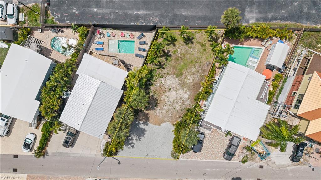 Build your dream home within easy walking distance to the beautiful sugar white sands of Fort Myers Beach. Located in the coveted weekly rental zone, this lot offers privacy but close enough proximity to the fun of vibrant restaurants, bars, and shops of Fort Myers Beach. The front of the lot provides a large parking area with pavers. There is a boat ramp at the end of the street providing easy access to the bay and Gulf. A short walk to  Beach Access #31 provides your route for a sunset walk to Margaritaville and beach bliss!