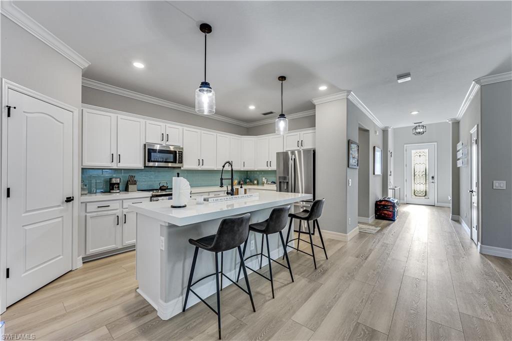 This beautifully updated single-story family home offers 4 spacious bedrooms and 3 full bathrooms with a functional open-concept layout designed for comfortable everyday living. The home features a newly renovated kitchen with modern finishes, updated cabinetry, sleek Quartz countertops, and new stainless steel appliances, creating the perfect space for cooking and entertaining. Brand-new luxury vinyl plank (LVP) flooring flows seamlessly throughout the bedrooms and the main areas of the home, complemented by fresh interior paint, new fans and light fixtures that give the space a bright, clean, and contemporary feel. Custom California Closets provide exceptional organization and storage solutions in the bedroom closets. With its thoughtful upgrades, generous living spaces, and move-in-ready condition, this home combines style, comfort, and practicality in one inviting package. Additional highlights include a screened lanai with tranquil private preserve views as well as EV Charging Station in the two-car garage. Located in the peaceful, gated community of Raffia Preserve, residents enjoy exceptional resort-style amenities including a clubhouse, resort-style pool, fitness center, basketball court, and beautifully maintained grounds all with low HOA fees. The community is located in an A-rated school zone and offers an unbeatable North Naples location just minutes from shopping and dining at Founders Square, Vanderbilt Commons, Galleria Shoppes at Vanderbilt, and Mercato, as well as Naples’ renowned white-sand beaches.