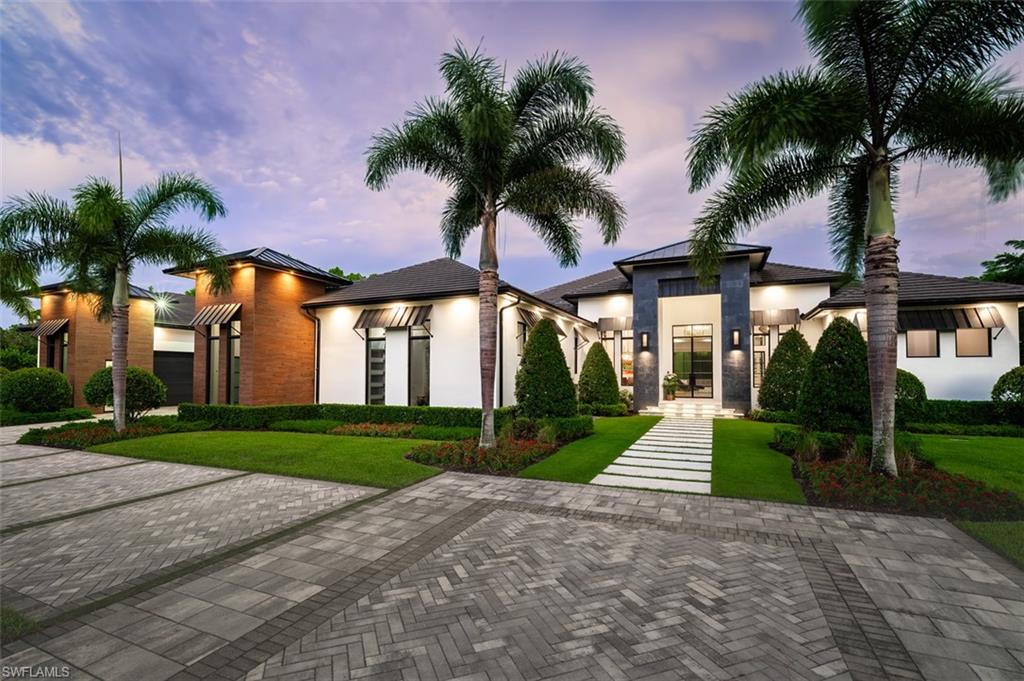 One or more photo(s) has been virtually staged, AI generated or rendered.  A rare offering in the heart of prestigious Pine Ridge Estates, this exceptional residence showcases a flawless blend of contemporary architecture, resort-inspired living, and uncompromising craftsmanship. From top to bottom, every inch of the home reflects meticulous attention to detail, creating an atmosphere of understated elegance and effortless sophistication. Designed for both grand entertaining and everyday comfort, the expansive floor plan is filled with natural light and seamlessly extends to spectacular outdoor living spaces through walls of glass. The gourmet kitchen serves as the centerpiece of the home, featuring professional-grade Wolf appliances, custom cabinetry, premium stone surfaces, and an oversized island ideal for gathering with family and guests. An impressive collection of lifestyle amenities elevates this residence well beyond the ordinary. Enjoy cinematic experiences in the private home theater, or retreat to the executive office for a quiet workspace. The luxurious primary suite is a private sanctuary, complete with a spa-caliber bath designed to rival five-star resorts, while thoughtfully separated guest accommodations ensure comfort and privacy for family and visitors alike.  Encompassing more than an acre of beautifully landscaped grounds, the outdoor setting has been designed as a private resort. Covered entertaining areas, a fully equipped summer kitchen, a sparkling pool with sun shelf, an elevated spa, fire features, and expansive green space provide the perfect backdrop for everything from elegant soirées to peaceful afternoons at home. Oversized separate garage space for all of your car, storage or man cave desires. Located just minutes from Naples' world-renowned beaches, fine dining, luxury shopping, and top-rated schools, this extraordinary Pine Ridge estate offers an exceptional opportunity to experience one of Southwest Florida's most coveted lifestyles. A residence of this caliber is far more than a home—it is a destination. One or more photo(s) has been virtually staged, AI generated or rendered