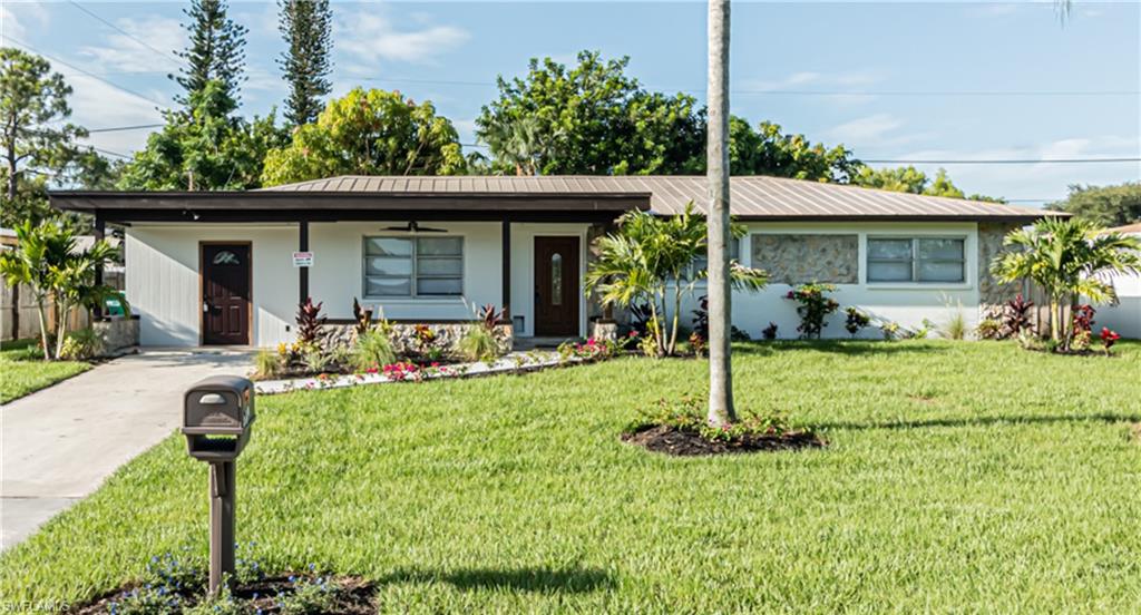 Seller will pay up to $10,000 towards buyer's closing cost with full price contract. Reduced $20,000 for quick sale.  Beautifully updated 3 bedroom, 2 bathroom concrete block home with a metal roof in Golden Gate City.  Neat and clean, no work needed on this one.  New 24 inch porcelain tile throughout, new paint inside and out, new fans and lighting, new cabinets, toilets, vanities, new irrigation system, new upgraded landscaping, new showers.  The entire lot has new sod.  There is a covered front porch and rear patio.  This home wont last long.  The home has an enclosed carport which was done by a previous owner.  This area is being converted back to a Carport.
