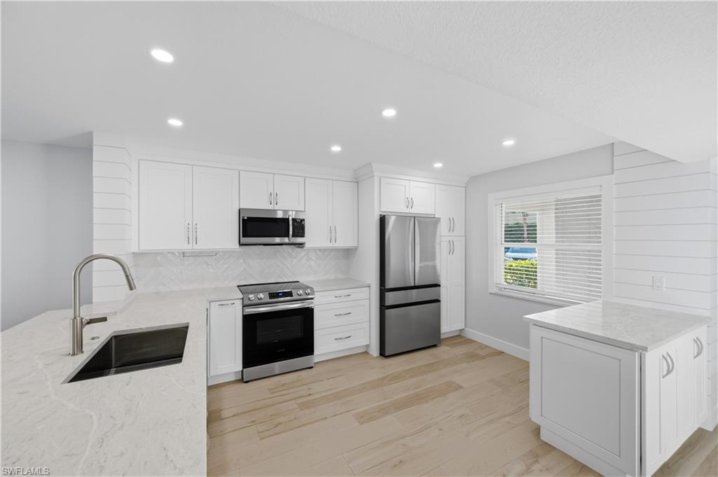 One or more photo(s) has been virtually staged, AI generated or rendered.  Wow—this one really has it all! This beautifully remodeled first-floor end unit in Berkshire Village feels brand-new the moment you walk in. The owners gave it a full luxury makeover: wood-look Italian porcelain tile, upgraded doors, fresh baseboards, new trims, a sleek new kitchen, and completely redesigned bathrooms. Every inch has been thoughtfully updated. The kitchen is bright and stylish, perfect for cooking, hosting, or just enjoying your morning coffee. Both bathrooms feel fresh and modern—like having your own mini spa at home. And the location? Amazing. You’re just minutes from Berkshire Commons (Publix, Starbucks, restaurants), close to everything Naples offers, and only a short drive to the beach. The community itself is peaceful and offers two pools where you can relax year-round. If you’ve been waiting for a move-in-ready condo with high-end finishes and a great Naples lifestyle, this is it.