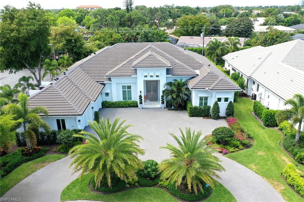 Experience Luxury in the heart of Naples. This stunning coastal inspired home is located in the most sought after location, just steps to Waterside Shops and Seagate Elementary.  Built in 2018, this home has fabulous finishes with 4000+- sq ft of living space.  An oversized pool/spa, pool bath, outdoor kitchen and spacious lanai complement the private setting for entertaining. This private tropical oasis offers a lush, gorgeous landscape. There are four bedrooms with en-suite baths, a formal powder room, great room with fireplace, and disappearing sliders to the lanai.  The beautiful gourmet chef inspired kitchen with double islands, complete with Wolfe, Bosch and Sub Zero appliances, built in ice maker, wine storage and separate wet bar with seating for six at the second island. The master suite has a sitting area with window bay overlooking the pool, two large walk in custom closets and a stunning master bath with oversized shower and separate soaking tub. The oversized three car garage measures 33 x 23. Spacious circular driveway and located on a cul-de-sac. This property is move in ready with designer furnishings included.