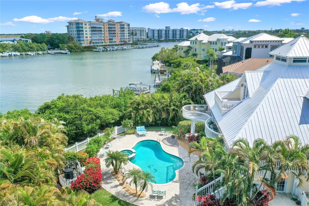 BAREFOOT BEACH    This stunning Old Florida style estate home in Southport on the Bay offers captivating bay views and direct gulf access. This open & light-filled coastal style home is suited for the ultimate Florida lifestyle. First floor features one bedroom, bath and living / entertaining area with French doors leading to the large pool deck. First floor also has two oversized one-car garages.  The second floor main living area features an open style kitchen with stainless steel appliances, living and dining area surrounded by outdoor wrap-around terraces with two en suite bedrooms. Third floor features a huge master suite with balcony capturing sunset views. Southport on the Bay is a gated waterfront community with low annual fees.