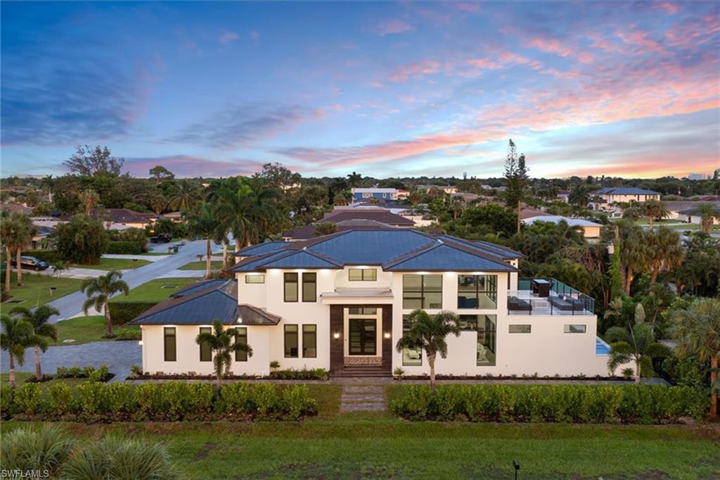 Immerse yourself in the vibrant Naples lifestyle with this new, two-story masterpiece at 9560 Vanderbilt Drive. Naples offers world-class dining, shopping and white sandy beaches, blending sophistication with relaxation. Just minutes from Vanderbilt Beach and Pelican Bay Community Park, featuring 20 pickleball courts, clay tennis courts and a shaded pavilion, this home is positioned for sports enthusiasts and coastal living. The modern architectural design boasts 22-foot ceilings and floor-to-ceiling windows. Inside, white oak hardwood flooring complements a gourmet kitchen with Viking appliances and custom cabinetry. Outdoor living is elevated with a large covered lanai, custom pool and spa, and a fully equipped outdoor kitchen featuring an Alfresco grill. Enjoy breathtaking sunset views from the upper deck as you unwind from the day’s activities. Retreat to the primary suite with two spacious walk-in closets and a spa-like bath. Each bedroom with en suite offers privacy and comfort, creating personal oases throughout the home. Built for safety, the elevated home is designed to protect against flooding, offering peace of mind in this prime coastal location.