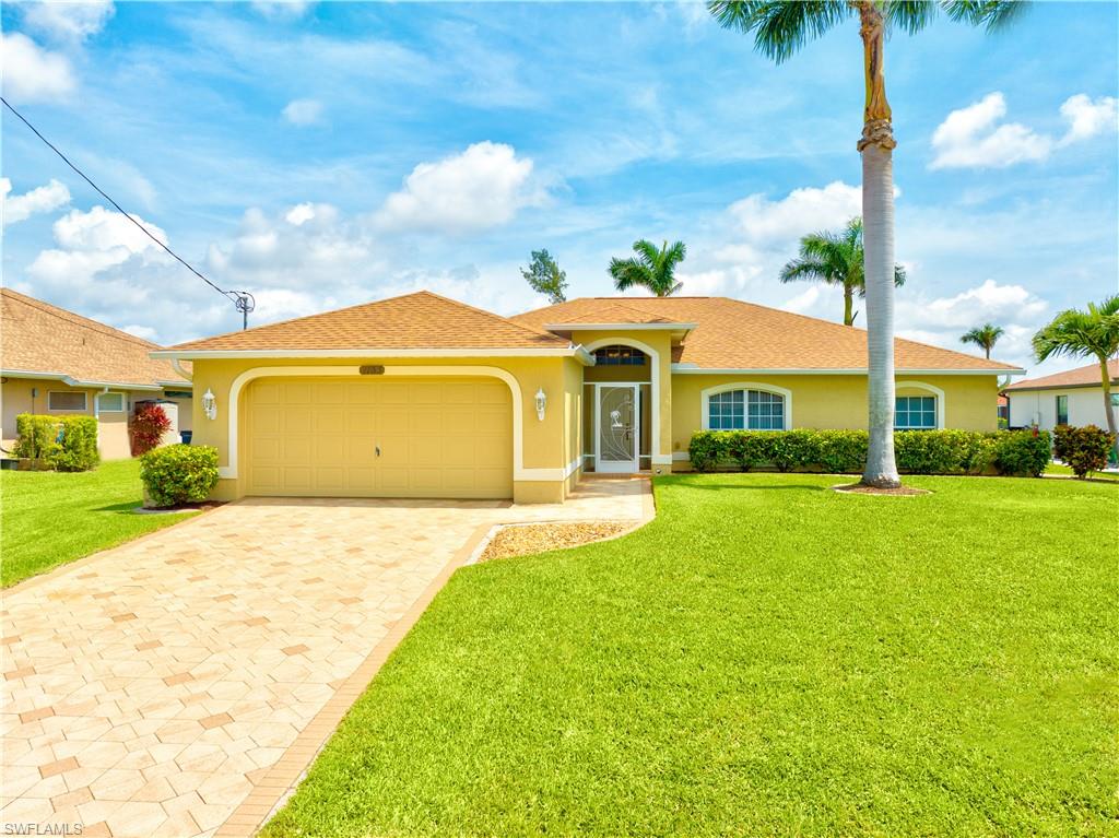 Welcome to your new home! Beautiful property located in highly desirable area of SW Cape Coral. 3-bedroom, 3 full bath waterfront pool home features paver driveway and pool deck with oversized cage.  Property also has a private dock, perfect for watching the wildlife, kayaking, fishing or just exploring the miles of waterways on the expansive canal system. Home features open floor plan with cathedral ceilings, huge master bedroom with attached bonus room (currently being used as a home office), and 2 nice size guest bedrooms, one with en suite pool bath.  Tiled throughout except in guest bedrooms.  Kitchen and laundry room have matching raised panel cabinets. Take advantage of the beautiful climate during season by opening the wall of pocket slides that gives an unobstructed view of the pool and canal and bring the indoors and outdoors together. Recent upgrades include a new roof, gutters, full cage re-screen & exterior paint in 2023, Coretec flooring in guest bedrooms 2022, A/C 2020. Close to many amenities, great shopping, restaurants, and entertainment minutes away from Cape Harbor and Tarpon Point. Bring an offer and start living in paradise!