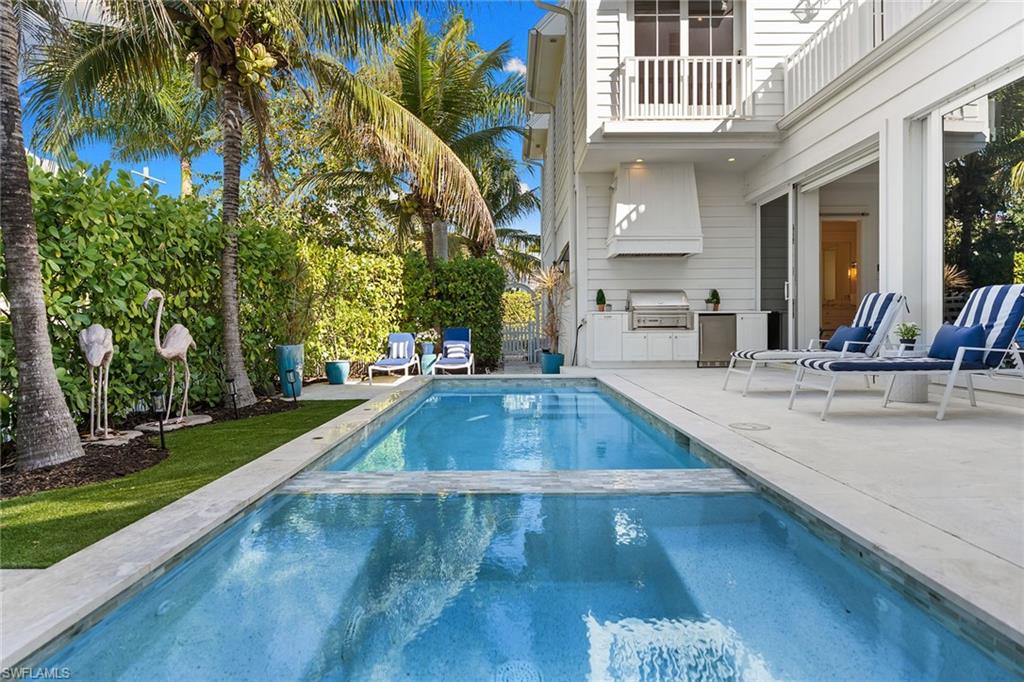 Ideally positioned on a sun-filled corner lot in the heart of Old Naples, this exceptional 2020-built residence blends timeless coastal elegance with thoughtful modern design. Just one block from Naples Bay and moments to dining and boutiques of 3rd Street South and 5th Avenue South, the location offers the best of accessible Naples living. Designed by MHK Architecture, the home is bright, open, and effortlessly inviting. Expansive windows flood the interiors with natural light, while refined stone flooring and curated finishes create a warm yet sophisticated aesthetic throughout. The thoughtfully designed floor plan features four bedrooms, including two luxurious primary suites, one on the first floor and a private retreat upstairs, offering flexibility for guests and multigenerational living. The main living spaces flow seamlessly to the outdoor area, embracing indoor-outdoor living. At the heart of the home, the chef’s kitchen is stunning and functional, appointed with marble countertops, a statement Lacanche range and oven, Sub-Zero refrigeration and custom cabinetry, a space equally suited for quiet mornings or lively entertaining. Outdoors, the western-exposure pool captures glowing afternoon light and vibrant Naples sunsets, while the corner lot setting enhances privacy and curb appeal. Lush landscaping and charming architectural details complete this coastal retreat. A rare opportunity to own a newer-construction home in Old Naples, just near Naples Bay and a short distance to the beach, fine dining and best of the Naples lifestyle.