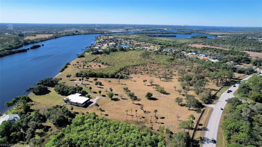 SPACIOUS, PRIVATE WATERFRONT RETREAT with ease of accessibility. Palm trees, Florida Sunshine, 30+ acres with over 1000 feet of river frontage offering Yacht access to both Gulf and Atlantic coasts! Situated only 2.5 miles to I-75, 15 mi. to Page Field Airport, 20 miles (approx 20 min) to RSW International Airport & less than 30 to Punta Gorda Airport for commercial or Private Jet service. This large Prime river front acreage is the perfect place to create your own Custom Executive Estate home or compound. Only 1.5 miles away is the Boat House Tiki Bar & Grill and Sweetwater Landing Marina. 6 mi up the road is Rosy Tomorrows Heritage Farm & Restaurant host to SWFL Wine Fest dinners and so much more! You will feel like you are out in the middle of nowhere yet you are mere minutes to somewhere!  Spacious and serene Olde Florida riverfront property that is host to Live Oaks draped in Spanish Moss that welcome you at the front gate and dot the landscape along with Sabal Palms, Carolina Willow, ferns and more. Consisting of 2 separate tax ids being sold as one package, could possibly be divided further should buyer choose to do so after purchase. Zoned for Ag, Residential & Preserve.