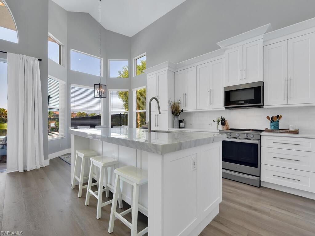 FANTASTIC home w/ the widest lake view in the community! This meticulously maintained & updated 2-story home w/ sprawling layout, volume ceilings, beautiful open concept kitchen, renovated baths, and amazing outdoor living space. The master suite & den/home office are on the first floor and situated off of the loft on the second floor you will find 3 guest rooms & a full bath. You will love relaxing or entertaining on the massive rear lanai that offers a covered sitting area, pavers on entire pool deck, and heated pool & spa. The roof is only 2 years old and the a/c was replaced 5 years ago. Saturnia Lakes has a very convenient Naples location w/ resort style amenities- clubhouse, fitness center, pool, tennis, & more!
