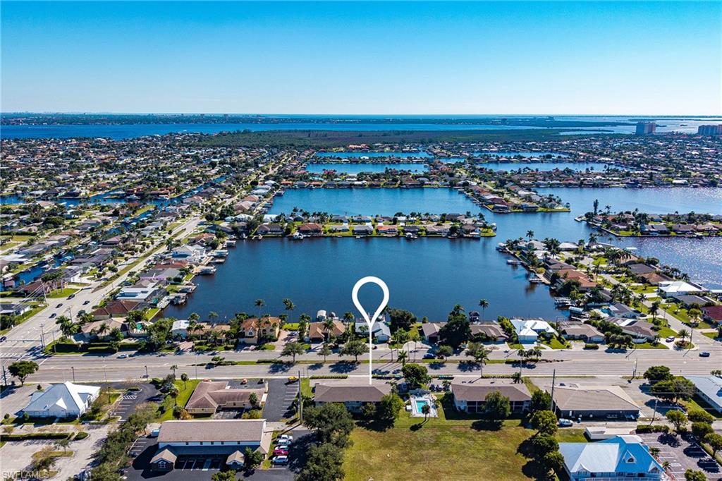 Lock-and-leave ease in a prime Cape Coral location, ideal as a vacation escape, full-time residence, or income-producing investment. This spacious 2-bed, 2-bath second-floor end unit sits in a well-kept community just minutes from Downtown Cape Coral. Inside, an open great-room layout is filled with natural light; the kitchen features stainless appliances and ample cabinetry and flows to a private screened balcony, perfect for morning coffee or cocktails in the Florida breeze. The primary suite offers a large walk-in closet, while the guest bedroom doubles nicely as a home office. Practical perks include in-unit laundry, an assigned parking space, and a community pool only steps from your door. With shopping, dining, and entertainment close by and quick access over the Cape Coral Bridge to Fort Myers beaches. This condo checks every box for lifestyle and convenience.