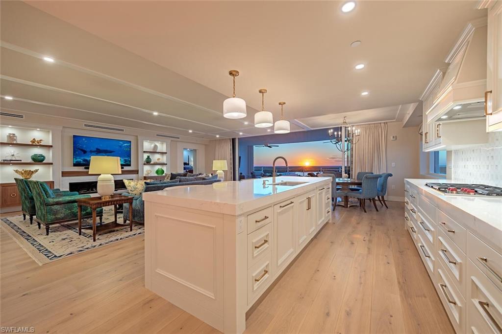 Elegant finishes and sophisticated design define this 6th-floor corner residence in Tower 300 at Kalea Bay. This turnkey home showcases professional interior design with luxurious furnishings, custom built-ins, exquisite millwork, designer wall coverings and lighting throughout.  A wall of sliding glass doors opens to a spacious lanai, offering breathtaking Gulf sunsets.  The residence lives like a single-family home, spanning 3,223 square feet with three bedrooms, a den with private balcony, and three-and-a-half baths, including a spectacular primary suite featuring a 9’x18.5’ custom closet. Highlights include Legno Bastone wide-plank oak floors, custom cabinetry, motorized shades, crown molding, a Kinetico water softener with carbon filter and RO drinking system and upgraded air purification.  The open gourmet kitchen boasts Wolf gas appliances, Sub-Zero refrigeration, a full-height wine cooler, and a butler’s pantry with ample storage. Enjoy direct elevator access to the building’s exceptional rooftop amenities, featuring a pool, open-air fitness center, BBQ grills, and lounge areas—all with sweeping Gulf views and unforgettable Naples sunsets. --- This Kalea Bay residence provides all the conveniences of living in a luxury condominium and membership to a private club with 5-star amenities, a combination that has made Kalea Bay one of the most successful and desirable communities in Naples.  Built in 2022, Tower 300 is located directly across from the Club at Kalea Bay and provides easy access to 80,000 square feet of exceptional modern amenities, including a wellness center with a state-of-the art gym, spin room, Pilates, spa services plus 3 resort style pools, 2 open-air poolside bars, fine and casual dining options, outdoor fire pits, a kids’ game room, 8 pickleball and 4 tennis courts, guest cottages and more. Kalea Bay Residents also have the option to join the annual Beach Card Program, based on availability, which grants access to the private Beach Club at Moraya Bay at Vanderbilt Beach for dining both indoor and outdoor as well as beach service including food, beverages, chairs and umbrellas.