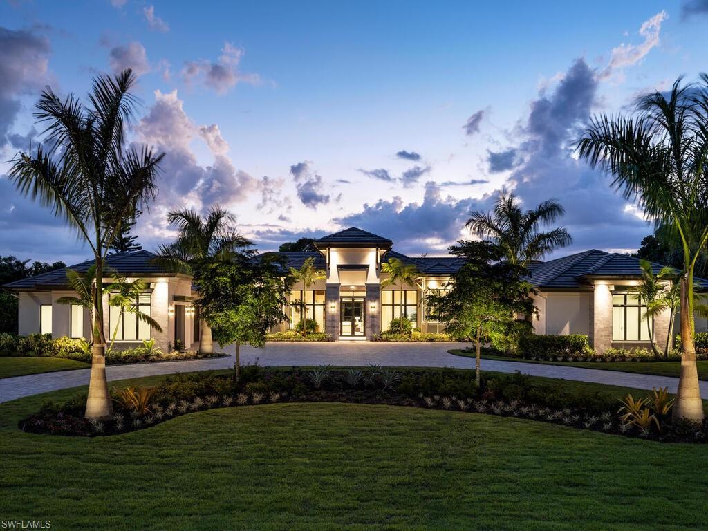 McGarvey Custom Homes presents an extraordinary new construction estate in one of Naples’ most sought after locations. This architectural masterpiece blends timeless sophistication with modern luxury, offering private resort style living just moments from world class beaches, dining, and shopping. From the moment you arrive, the property makes an unforgettable impression with dramatic architectural lines and honed quartzite elevation accents. Custom Cantera steel double entry doors open to a stunning glass lined foyer that frames views of the expansive outdoor oasis. Two gated driveway entrances lead to an impressive brick paver motor court offering both convenience and security. Alfresco ready, the residence features an exceptional outdoor living area complete with water features, a custom pool, spa, sun shelf, outdoor kitchen, dining area, fireplace, and a separate firepit—perfect for relaxing or entertaining. Shellstone porcelain deck pavers, lush tropical landscaping, a mosquito mist system, and automated screens and hurricane shutters enhance both comfort and peace of mind. Inside, the home’s designer curated interiors deliver unmatched refinement. The plan includes five spacious bedrooms, six full baths, two half baths, a private study, and a versatile flex room. A divided layout provides ultimate privacy, with the luxurious primary suite on its own wing. Throughout the home, you’ll find distinctive ceiling details with accent lighting, French oak hardwood flooring, level 5 smooth-walls, and beautifully executed tilework. The gourmet kitchen is a chef’s dream, featuring bespoke cabinetry, an oversized island with Caesarstone Darcrest honed quartz, Pompeii quartz perimeter countertops, designer plumbing fixtures, and a Sub Zero/Wolf appliance suite. Under and above cabinet lighting with glass accents highlight the craftsmanship and create a warm, inviting atmosphere. The primary suite is a serene retreat with panoramic views of the pool and lush rear grounds. The spa inspired bath offers a freestanding soaking tub, walk in shower, dual vanities, premium cabinetry, quartz countertops, and his and her water closets featuring Toto automated toilets. Walk in closets with custom storage and a private courtyard view complete the space. A morning bar and undercounter refrigerator add an extra layer of indulgence. Designed with modern living in mind, the home features an advanced low voltage electrical systmem, automated lighting controls, whole home standby generator, landscape lighting, and wiring for data, voice, and video. Efficiency and comfort are further enhanced by Icynene spray foam, sound batt insulation, high efficiency HVAC with dehumidification system, tankless gas water heaters with recirculation, and a 1,000 gallon propane tank. Fully furnished by Tina Marie Interiors, this exceptional estate offers a rare opportunity to own a luxury residence that merges exquisite design, premium craftsmanship, and the best of Naples’ lifestyle.