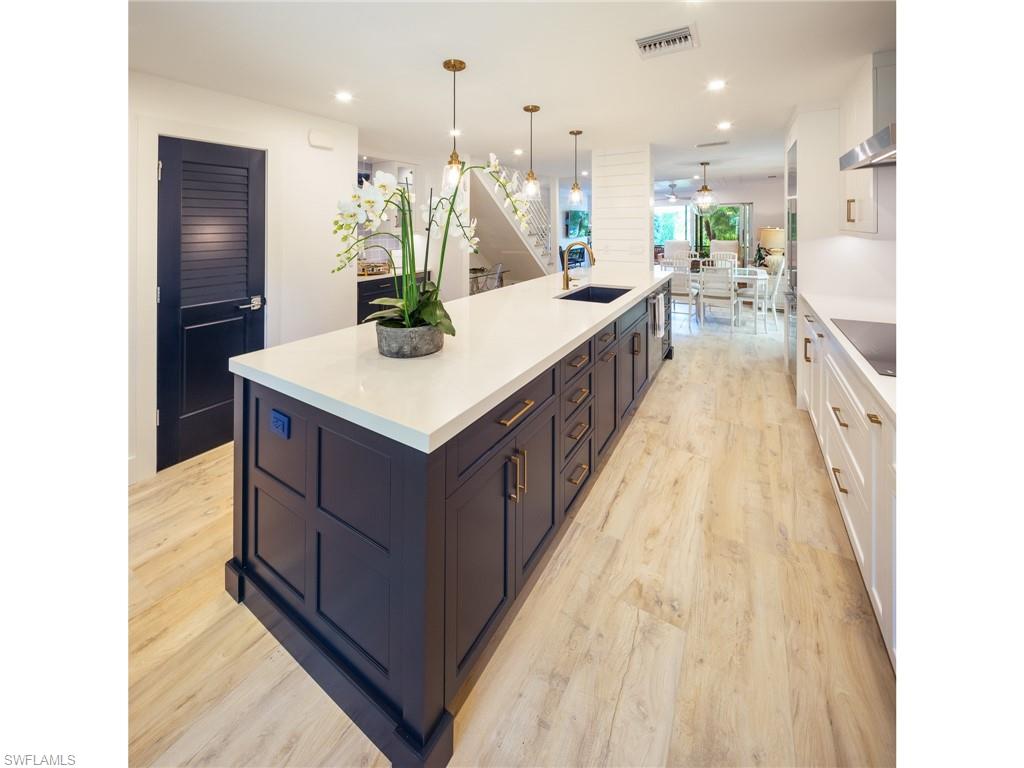 Total re-imagination & renovation of this end unit space just completed in addition to a location that can't be beaten!  Walk to Naples finest beaches, 5th Ave & 3rd St dining & shopping, yet enjoy quiet privacy at home. Open floor plan with dream kitchen, bar, window seat & home office area. Soft close doors, pull outs or drawers in all base cabinets, designer backsplashes and more storage than you can imagine. Kit/bar/bathrooms all Quantum White Quartz. Upscale Fisher Paykel refrigerator & DW, induction cooking. Doors throughout were custom matched to island. All new impact glass windows and sliding glass doors. Enjoy cozy evenings by your gorgeous fireplace or wine on one of 2 lanais overlooking the quiet pool area. First level is hardwood look tile to match the french oak hardwood stairs & 2nd level. Small home office added beneath stairs for longer stays. Shiplap touches on walls/ceilings...no detail overlooked. NEW ROOF 2019, NEW PARKING PAVERS 2020, 1 covered carport space + 1 uncovered space behind it. Additional guest parking available. All you need is to unpack your clothes and begin living the fabulous Olde Naples lifestyle.