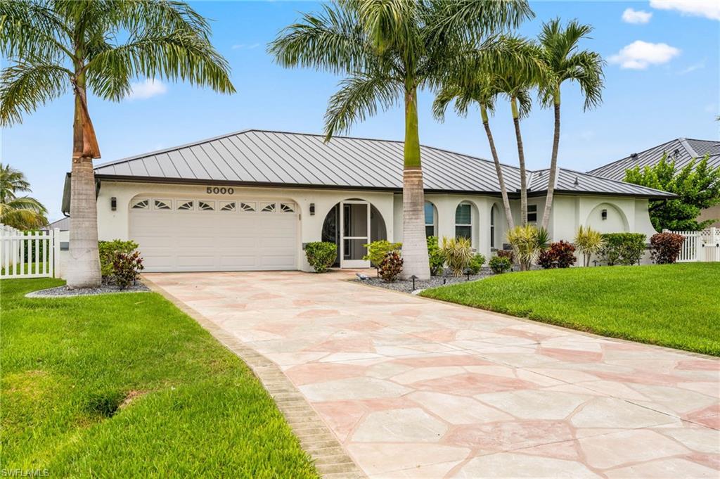 Located in a very desirable neighborhood in SW Cape Coral, this beautifully maintained home is being offered TURNKEY FURNISHED to make your move as seamless and easy as possible. The Western Rear Exposure will capture some of the most beautiful Florida sunsets you’ve ever seen, while also providing full sunlight on your Private Pool year-round. The floor plan is spacious and offers 3 Large Bedrooms with oversized walk-in closets, 2 Full Baths, a Living Room, Dining Room, Kitchen, Indoor Laundry Room, and a 2-car Garage. Features include Vaulted Ceilings, Custom Built-ins, Updated Kitchen & Baths, Decorative Lighting & Fans, a Standing Seam Metal Roof (2023), New A/C (2023), Water Softener System, Impact Resistant Windows, a combination of Electric & Manual Hurricane Shutters, and so much more! Step outside to the outdoor area and you will find a Sparkling Heated Pool with a Brick Paver Pool Deck, a Large Covered Lanai, and a Panoramic Picture Window Screen Enclosure that provides gorgeous water views of the 150’ Wide Orion Canal. Boating enthusiasts will appreciate the Wrap-around Composite Boat Dock with a 16,000 lb. Boat Lift, and easy access to The Gulf. The home has never experienced water intrusion from hurricanes and includes an assumable flood insurance policy. Offered turnkey furnished and meticulously maintained, this home is ideal as a full-time residence, seasonal retreat, or investment property. Conveniently located near Cape Harbour, Tarpon Point, Camelot Isles Shopping Center, waterfront dining, shopping, entertainment, and Camelot Park featuring pickleball, tennis, and playground amenities. Don't let this one slip away—secure your Piece of Paradise today!
