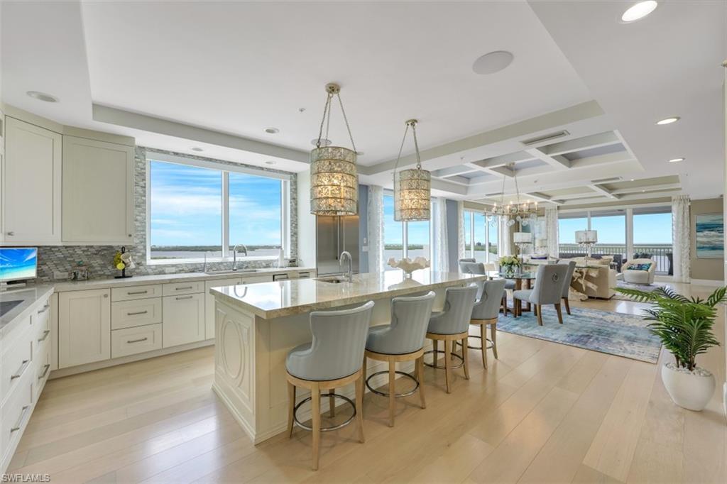 Fall in love w/this gorgeous home located in Bonita Bay's newest high rise, Seaglass of Bonita Bay! Upon entering this home, you will be mesmerized! Floor to ceiling windows & unmatched views on 3 sides with a PRIVATE 2 CAR GARAGE on the 2nd floor - this is only the beginning! Be impressed by the LUXURIOUS finishes & great attention to the smallest of details. Over 3400 sq ft under air, boasting 3BR PLUS a den, friends & family will comfortably visit!  Sophisticated & stately, this home is conveyed w/countless custom upgrades including American oak floors throughout, BRAND NEW carpeting in BRs & den, NEW electric hurricane shutters, EXTRA STORAGE CLOSET, CUSTOM WALK-IN PANTRY, 2" thick quartzite countertops, CUSTOM cabinetry, light fixtures, window treatments, closets & so much more! The master BR is impressive & allows access to the lanai. The MBR boasts upgraded counter-tops & oversized shower. Guest BRs offer en-suite baths & balconies. Complete w/large den/office, this unit lives like a single family home. You will love the Western facing lanai w/SO MUCH ROOM for enjoying FABULOUS sunset views, outdoor cooking/dining & relaxing w/your favorite cocktail. SEE ACCOMPANYING VIDEO!