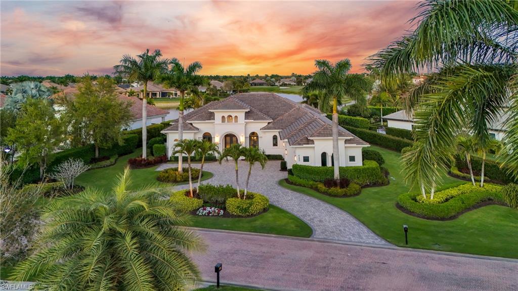 Lakefront home with custom 50 foot lap pool and 3-car garage on an oversized home site. Immediate golf membership available. Extensively renovated and expanded in 2022, this home offers panoramic lake and golf course views, 4 bedrooms, two offices, and 4.5 baths. A 3-foot stem wall elevation offers enhanced view perspective and flood protection. A 2025 refresh added updated exterior paint, architectural façade and entryway enhancements, and custom coach lighting. Interior features include 16-foot ceilings and a floor to ceiling iced quartz fireplace with LED accent and tray lighting, creating a focal point in the living room. The open concept kitchen offers two large islands, ceiling height cabinetry, and a large butler’s pantry (pre-plumbed for a wet bar) with a wine refrigerator. A custom 5-foot extension expands the second bedroom into a spacious guest retreat with dual vanities and a full bath. In addition to the bedroom suites, the home includes two offices (one with direct lake and golf course views) and one bedroom set up as a dedicated fitness room. The primary suite features expansive windows and doors overlooking the pool and lake, a spa-style bath with dual vanities and an upgraded Kohler multi function shower system, and custom finished his and hers closets. All lakefront view rooms include motorized UV filtering shades. The upgraded outdoor living area includes a 50-foot saltwater lap pool and spa with sun shelf, gas pool/spa heater, motorized roll down screens and hurricane shutters, and tongue and groove wood ceilings across both covered lanais. Seamless porcelain plank flooring extends from the interior living spaces to the lanai for indoor-outdoor continuity. The large, fenced backyard is bordered by mature 10-foot privacy hedges, providing a private setting with lake and golf course orientation. The fully enclosed yard offers ample space for pets and outdoor activities. Additional improvements include hurricane rated windows and doors, reinforced impact/cyclic rated Amarr Lincoln garage doors, three zone A/C, a whole home Generac generator, a smart security and camera system, and a 3-car garage with space to add a fourth bay. Updates throughout support a move in ready experience; see the features list for additional details. Situated on over half an acre in Quail West with a Collier County address. Community amenities include a clubhouse, two championship golf courses, fitness and spa facilities, tennis, pickleball, and dining options (membership required).