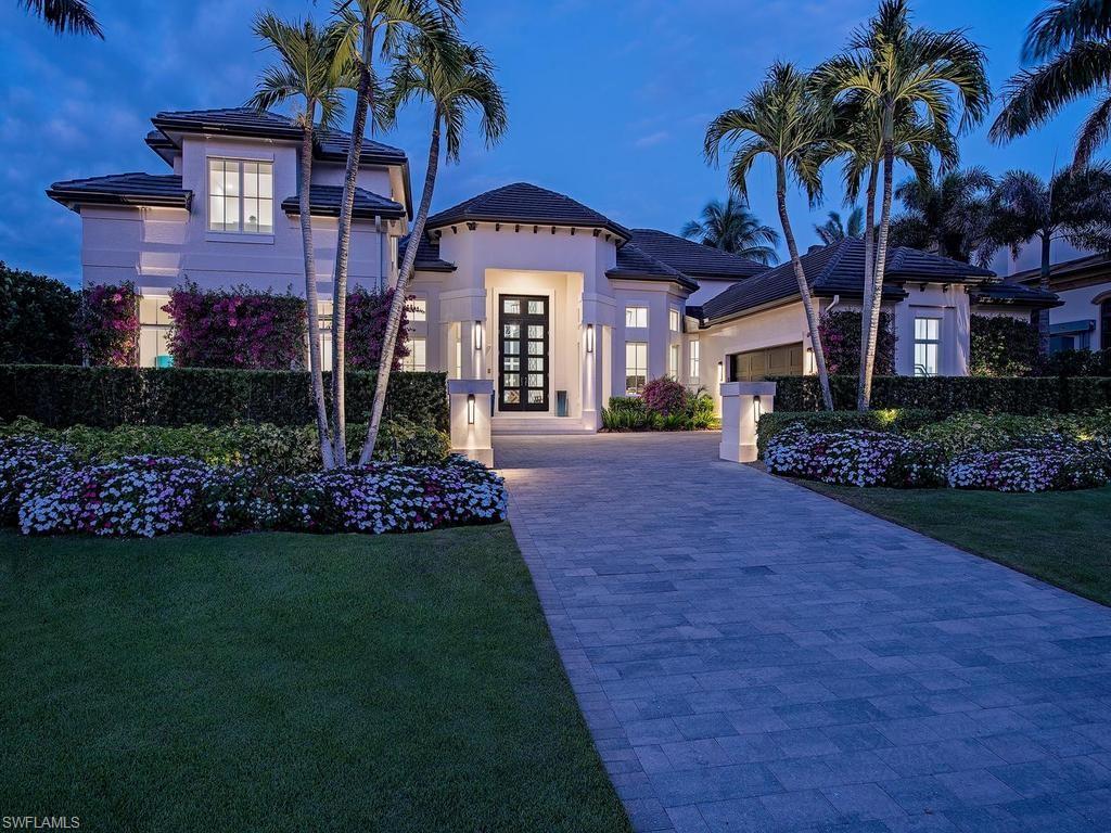 Positioned on prestigious 4th Street South in coveted Aqualane Shores, this exceptional five bedroom, six and a half bath estate sits on a breathtaking 200-foot-wide canal with direct, bridge-free Gulf access. Whether you're an avid boater or simply drawn to waterfront tranquility, the property's marine amenities are second to none, featuring two boat lifts including a platform for two jet skis, a 24,000 pound lift, and a commanding 50-foot floating dock. Two air-conditioned, two-car garages provide four covered parking spaces. Interior finishes are exceptional, with Ruffino custom cabinetry, Cristallo quartzite surfaces, and wide-plank Legno Bastone flooring setting a tone of coastal elegance throughout. Six full baths and a powder room are finished to the same exacting standard. Motorized shades on every opening, a whole-home Nice automation system, FloLogic water monitoring, and dual Navien tankless water heaters ensure effortless comfort and peace of mind. Outside, a resort-style pool and spa anchor a covered lanai with sweeping canal views. Moments from 3rd Street South, 5th Avenue, and the Gulf beaches, this is Naples living at its finest.