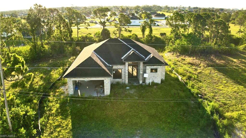 Exceptional opportunity to own a partially completed new construction in one of the fastest-growing areas of Northwest Cape Coral! This spacious home offers 4 bedrooms, 3 full bathrooms, and a 2-car garage with an oversized driveway, providing an excellent canvas for investors, builders, or buyers looking to personalize their dream home.

The property is being sold AS-IS in its current stage of construction. Major progress has already been completed, including roof framing, plumbing rough-in, and electrical wiring throughout the home. The seller will complete the roof prior to closing. A full set of building plans is available for the buyer. (Out of a flood Zone.)

Inside, you'll appreciate the thoughtfully designed split-bedroom floor plan with soaring ceilings, an open-concept living area, and large impact windows and sliding glass doors that bring in abundant natural light. The backyard overlooks a freshwater canal, offering peaceful views and plenty of room to build a custom pool, creating the perfect Florida outdoor living space.

Located in a rapidly expanding area surrounded by beautiful new construction, this property benefits from continued residential and commercial growth, with ongoing development throughout Northwest Cape Coral.

Conveniently located near shopping, dining, grocery stores, schools, parks, medical facilities, and everyday conveniences, including Publix, ALDI, Walmart, Coral Shores Shopping Center, Cape Coral Hospital, Burnt Store Boat Ramp, and the exciting Seven Islands development, making this an outstanding location for future appreciation.

Bring your reasonable offers! The seller is motivated and open to reviewing all serious proposals. Don't miss this unique opportunity to finish and customize a quality home in one of Cape Coral's most promising neighborhoods.