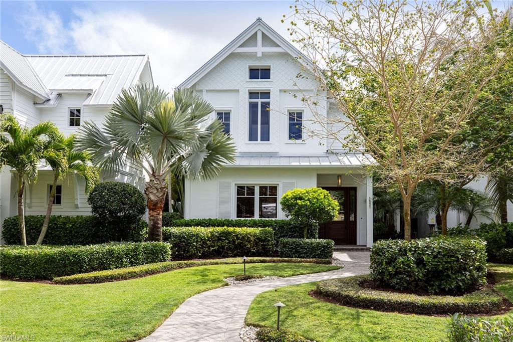 Sited in the heart of Old Naples, this modern cottage designed by MHK Architecture is a short walk to the Gulf beach, 3rd Street South and 5th Avenue South. Wide-planked wood floors, floor-to-ceiling glass and ceiling details frame the easy style of this home. The lower level features a generously sized living area, dining area with wet bar and beverage center, crisp, white kitchen with island, powder bath and grand entry to the private outdoor living. The heated pool/spa are surrounded by marble pavers, a trio of cascading fountains and lush landscaping. A gas fireplace and mounted TV are perfect for entertaining. The kitchen includes a suite of Thermador appliances, soft-close cabinetry, quartzite countertops, double sink and island. The oversized master suite includes an entry with wet bar, generous seating area, Juliet balcony, two walk-in closets, two separate vanities, freestanding tub and separate shower. Guest rooms are large enough for king beds and have private bath access. All baths are well-appointed with natural stone. The upstairs loft may be open for all to enjoy or closed off for privacy to work out, work, watch TV, enjoy puzzles and more.