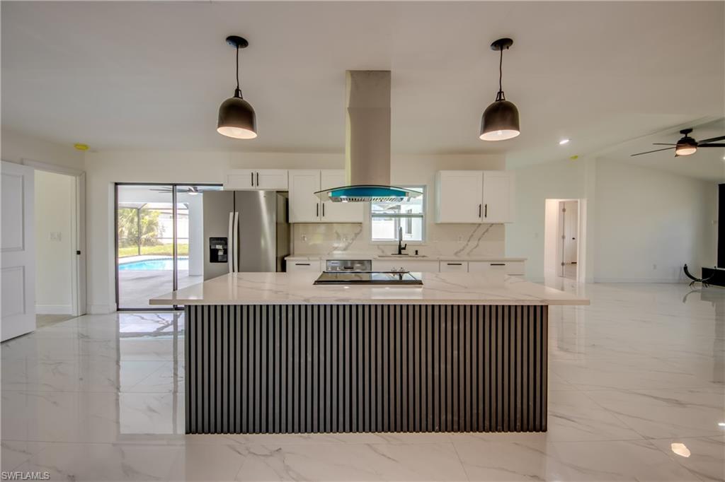 WHAT IF YOU COULD HAVE THE QUALITY OF A CUSTOM HOME WITHOUT THE CUSTOM HOME PRICE TAG? This REMARKABLE POOL HOME delivers exactly that. Remodeled under the direction of a builder whose career has been defined by craftsmanship, every improvement was completed with a level of care, precision and finish quality that is increasingly difficult to find. Walls removed, spaces were opened and the result is a LIGHT-FILLED OPEN GREATROOM FLOOR PLAN designed for the way people live and entertain today. Sunshine streams through NEW IMPACT GLASS WINDOWS and reflects beautifully off stunning oversized floor tiles. If there is a showpiece in this home, this Kitchen is it! Beautifully designed it combines clean lines, timeless finishes and exceptional functionality with WHITE SOFT-CLOSE WOOD CABINETRY, QUARTZ COUNTERTOPS, STAINLESS STEEL APPLIANCES, and a COMMERCIAL-GRADE RANGE HOOD that serves as a striking focal point. The family room features VAULTED CEILINGS, a WOOD-BURNING FIREPLACE, and a stunning fluted accent wall that adds warmth, texture and designer character. For buyers who appreciate QUALITY and CRAFTSMANSHIP OVER SHORTCUTS, this home delivers something increasingly difficult to find. The PRIMARY SUITE is beautifully remodeled and features DUAL VANITIES, DUAL SINKS, a JETTED SOAKING TUB, SEPARATE SHOWER and WALK-IN CLOSET. Meanwhile, the guest bedrooms enjoy their own private wing, sharing an UPDATED GUEST BATHROOM that conveniently doubles as a POOL BATH. The list of improvements is extensive and includes HVAC SYSTEM AND DUCTWORK, IMPACT GLASS WINDOWS, ELECTRICAL PANEL, CERAMIC TILE FLOORING, LAMINATE FLOORING, INTERIOR AND EXTERIOR PAINT, DOORS AND TRIM, WELL, COMPLETELY REMODELED KITCHEN, COMPLETELY REMODELED BATHROOMS, POOL PUMP, POOL FILTER, and LANAI SCREENS. (While all windows and one sliding glass door have been upgraded to IMPACT GLASS, the remaining sliders are original.) Even better, NO FLOOD INSURANCE IS REQUIRED. All this and a 3 LOT SITE to boot! Huge yard for family and pets. There is NO HOA, making this a PET-FRIENDLY and RENTAL-FRIENDLY neighborhood. Located in one of Cape Coral’s most convenient NW Cape locations, you’ll enjoy easy access to shopping, restaurants, healthcare facilities, golf courses, parks, pickleball, boat ramps, entertainment, and nearby Fort Myers. Cape Coral is famous for its 400+ MILES OF CANALS, outstanding boating and fishing opportunities, waterfront dining, nearby GULF BEACHES, RSW International Airport, Punta Gorda Airport and year-round outdoor lifestyle. Whether your perfect day includes a boat ride, beach sunset, waterfront dinner, or simply relaxing beside your own pool, this location puts it all within reach. In a market filled with houses that look similar on paper, this is the one DISCERNING BUYERS remember. The QUALITY is visible. The CRAFTSMANSHIP is evident. And the opportunity to own a home like this at this price point is increasingly rare. GOOD NEWS: IT LOOKS THIS GOOD IN PERSON TOO!