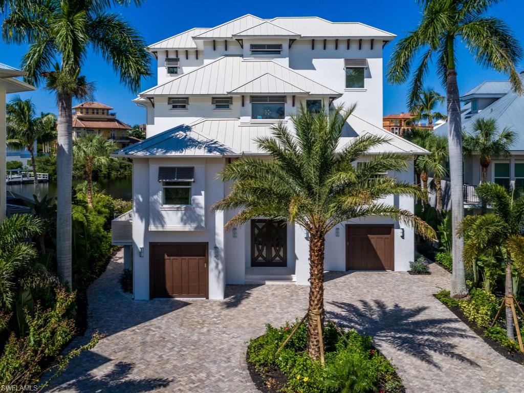 Presenting Barefoot Beach's finest available luxury bay home. This 4-story Bayfront Gardens home features an exquisite coastal style. Incredible bayfront setting with panoramic views on a very rare western exposure bay lot. 4 bedrooms, true office, top level cloud room w/sleeping & full bath. 5.5 total baths. The main level of this home is expansive w/wide plank oak flooring, a fully equipped bar, priv elevator, & a stunning 11 foot kitchen island. The master suite level is first class taking the entire floor with an enormous walk in closet w/private laundry, wet bar & large space including writing desk space and bay front lanai. The top floor cloud room offers a custom bar and fantastic family entertaining space, full bath, and postcard deck presenting some of the best bay views in Barefoot Beach! The elevated pool area offers exotic decking, sit up pool bar, built in gas grill, & direct access to boat & jet ski lifts. Additionally, this property sits behind two gates & features a private beach access to the areas finest beach! Approximately 7,100 sq ft living space 11,500 total sq ft including pool and deck areas. Furniture & furnishings negotiable.