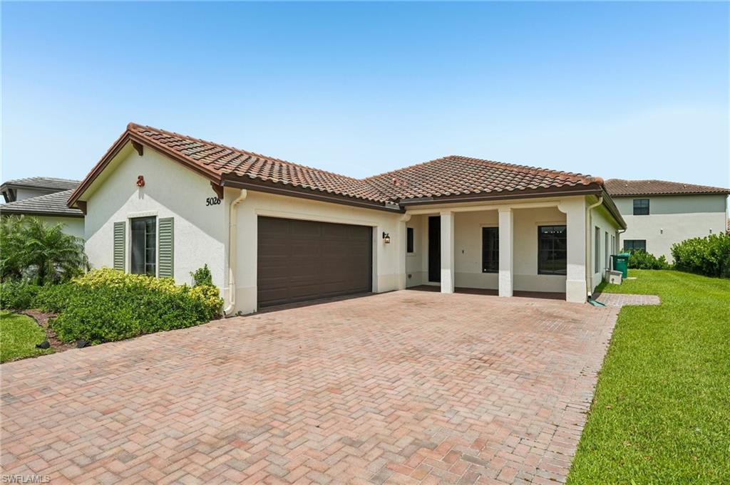 One or more photo(s) has been virtually staged, AI generated or rendered.  Welcome to this beautifully maintained, highly desirable 3 bedroom plus den, 3 full bathroom Roosevelt floorplan, with 2-car garage.  This home features an open-concept layout with 9’ ceilings, and modern finishes throughout. The spacious living and dining areas are filled with natural light and highlighted by wood-look LVP. A striking custom feature wall with a built-in electric fireplace creates a stylish focal point adjacent to additional dining nook and kitchen. The white shaker kitchen is equipped with quartz countertops, a large center island with seating, and ample storage space with a walk-in pantry. The split-bedroom floor plan provides privacy, while the versatile den is ideal for a home office or media room; however, it has plenty of space for a closet to be added to create an additional bedroom. The primary suite includes dual vanities and a large glass enclosed shower plus double walk-in closets. Additional highlights include upgraded 42” cabinetry throughout, Sonos speakers in ceiling and some Smart Home features.  Large paver driveway and covered front entry greet guests.  Step outback to the extended paver lanai with peaceful lake views and plenty of room to relax or entertain.  This blank canvas is awaiting your ideas and personal touches with the space for an outdoor kitchen and/or pool. Move-in ready and conveniently located near shopping, dining, schools, and major roadways.  This home offers comfort, style, and functionality all in one.