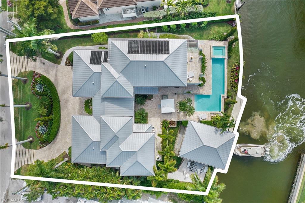 HUGE Price adjustment-Priced BELOW Appraised Value. This Estate Size Lot is set on an exceptional waterfront parcel of almost half an acre of land, this coastal built estate home offers a rare combination of privacy, scale, and true boating lifestyle. Designed with privacy in mind, the home unfolds around resort-style outdoor living with a long, linear pool, multiple entertaining terraces, and a covered boathouse for effortless waterfront access. Mature tropical landscaping, generous setbacks, and thoughtful architectural separation create a sense of seclusion seldom found in Royal Harbor. Built to modern standards and conceived for both everyday living and large-scale entertaining, this is a waterfront estate that delivers lifestyle, land, and longevity — not simply square footage. Home details and upgrades include: One of the few Grandfathered in, Cut-in Covered Boat Houses with 16,000# remote controlled 4 motor boat lift (upgradeable if needed) currently accommodates up to a 30’ boat. , De-humidified & A/C 4-car garage. Whole house generator w/ a 1,000-gallon propane tank + a 2nd 250 gallon tank for stove/fireplace/grill & 400k BTU back up pool heater, electric privacy shades, electric awnings for shaded areas, impact windows, reverse osmosis water filtration system, extra icemaker drawer, wine refrigerator, and the list goes on.