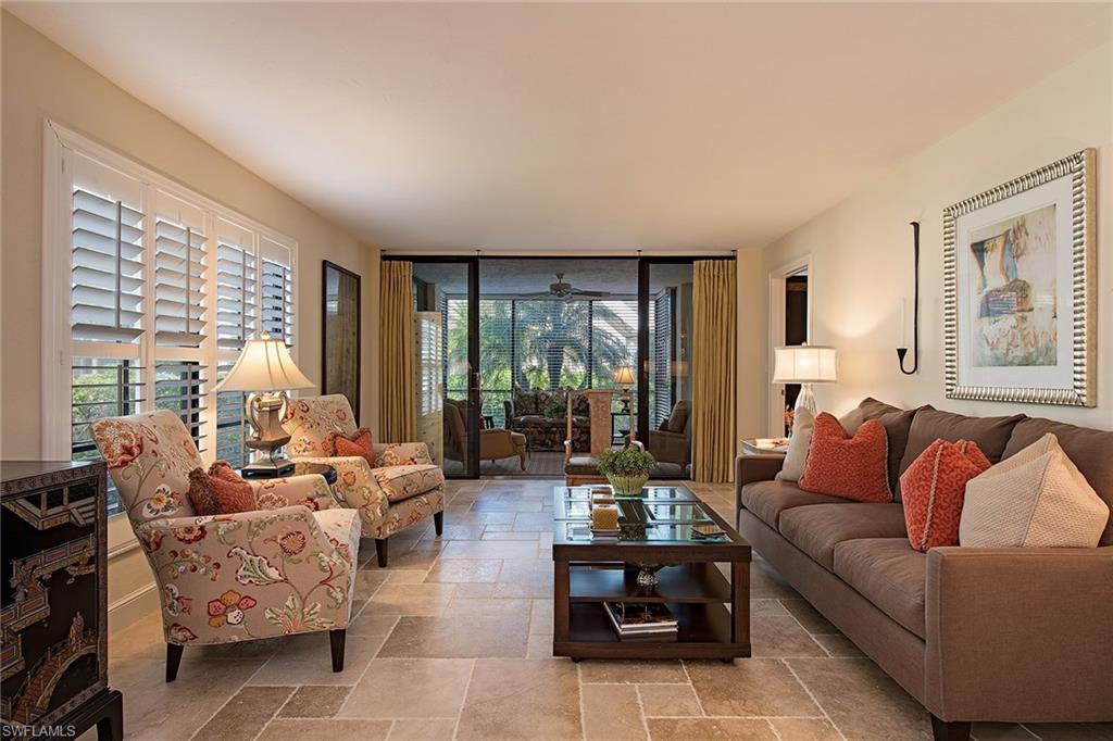 Enjoy this beautifully remodeled, two-bedroom-plus-den, first-floor condominium located west of 41, with ample space for friends and family to relax. At this beautiful residence at Somerset at the Moorings, all the hard work has been done. An air-conditioned sunroom overlooks tropical greenery towards the community pool, while a sunny south-facing screened porch is the perfect spot to enjoy your morning coffee.  The remodeled kitchen features Dutch Made custom cabinets with full extension pull-outs, lighted glass-fronted upper cabinets and granite countertops. The flooring throughout is Versailles-patterned sealed travertine. The den has French doors and a clever built-in with storage/closet space. Windows on three sides mean light and air fill this comfortable condominium. Covered and open parking, extra storage, and Moorings Beach memberships are available.
