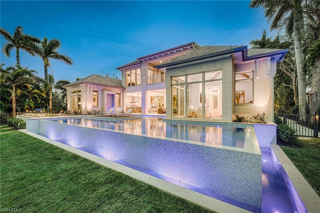 An elegant coastal retreat, this 8,000 square foot home delivers ample space for large family gatherings or cherished guests. The sprawling floorplan includes a luxurious primary suite overlooking the pool, 5 generous and unique guest suites, a comfortable second living space, and an office adjacent to the primary suite. Designed with care and attention, each detail has been carefully planned and held to the highest standard. Wide-plank oak flooring, custom walnut cabinetry, and hand selected marble and quartzite accents elevate the living spaces; while the Lutron lighting, integrated electric shades, whole home generator, two separate laundry rooms, and a residential elevator provide ultimate convenience. The stunning pool serves as the home’s visual focal point, with Ipe wood decking, oversized stepping-stone walkway, and a wall fountain accent. Andersen Liftslide Doors allow for abundant natural light inside the home and effortlessly pocket away for a truly seamless transition between the outdoor and indoor spaces. This home enjoys deep water access to the Gulf and is available for immediate Port Royal Club membership.