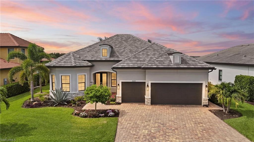 Experience luxury lakefront living in one of Southwest Florida's most sought-after resort communities. Perfectly positioned on a premium homesite with coveted southern exposure & breathtaking views of Corkscrew Shores' spectacular 240-acre lake, this highly upgraded Pinnacle floor plan offers 3 beds plus a den, 3 full baths, 2,488 sq. ft. of living space, and an exceptional indoor-outdoor lifestyle.

The open-concept floor plan showcases soaring tray ceilings, 12x24 tile flooring, crown molding, plantation shutters, hurricane impact windows and doors, designer lighting, and expansive zero-corner sliding glass doors that seamlessly connect the interior to the outdoor living area.

The custom gourmet kitchen is a showpiece, featuring an oversized 12-foot quartz island, extra-tall white shaker cabinetry with stacked glass display cabinets, KitchenAid stainless steel appliances, wall ovens, cooktop, wine cooler, walk-in custom pantry, and abundant storage. The spacious dining and great room capture stunning long lake views from nearly every angle.

Retreat to the luxurious owner's suite featuring a custom walk-in closet system and a beautifully updated spa-inspired bath with dual vanities, quartz countertops, lighted mirrors, and frameless glass shower . A private den with French doors provides the ideal home office, media room, or guest overflow space.

Outdoor living is where this home truly shines. The oversized covered lanai features remote-controlled storm screens, a picture-frame cage, travertine decking, professional landscape lighting, and an expansive saltwater pool with sun shelf and dual waterfalls. Enjoy unobstructed panoramic views across the lake toward the community pier and amenity island—creating one of the most picturesque waterfront settings in Corkscrew Shores.

The extended 3-car garage is loaded with upgrades including epoxy flooring, EV charger, air conditioning, built-in storage systems, utility sink, ceiling-mounted bike storage, overhead storage racks, attic access with built-in storage, additional outlets and lighting, and a custom double-door storage closet.
Additional features include a whole-house water softening system, upgraded laundry room cabinetry with removable countertop access, enhanced garage organization systems, custom closet built-ins, professional landscaping, and outdoor accent lighting.

Corkscrew Shores offers a resort lifestyle centered around a 240-acre recreational lake. Residents enjoy a lakefront clubhouse situated on a private island, The Captain's Club restaurant and bar, resort-style pool and spa, 24-hour fitness, tennis, pickleball, bocce, fishing pier, fire pit, kayak/canoe launch, &  a vibrant social calendar. 

This is a rare opportunity to own a highly upgraded lakefront pool home with southern exposure, panoramic water views, hurricane impact windows, a 3-car air-conditioned garage, NO CDD, LOW HOA Fees, & resort-style amenities in one of Estero's premier gated communities.