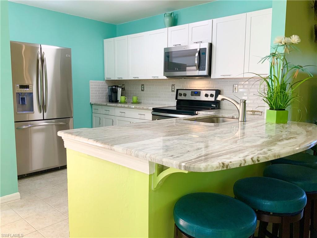 BRIGHT COASTAL CUTENESS - FIRST FLOOR - BEING SOLD TURNKEY! This 3 bedroom, 2 bath, end unit has many updates and is move-in ready. Some of the recent updates include stainless steel appliances, expanded granite countertop, white Shaker style cabinets, and subway tile backsplash in the kitchen.  The baths are updated with new vanities and granite tops. The Master has a large walk-in, tiled shower, with glass doors and a glass vessel sink. Neutral tile, five designer ceiling fans and custom colors throughout. Newer full size stackable washer and dryer and the water heater was replaced in 2018. The well appointed furnishings and accessories are all done for you...just bring your toothbrush. Relax on the screened lanai overlooking your private and fenced courtyard. All this and Location, Location, Location! Just minutes to white sandy beaches, shopping, dining and entertainment. Bellamar is a gated community with a large community pool, hot tub, clubhouse, and fitness center. It is pet friendly and has low monthly fees. This is easy Florida living at its best and this great condo will not disappoint. Call to schedule your private tour today!