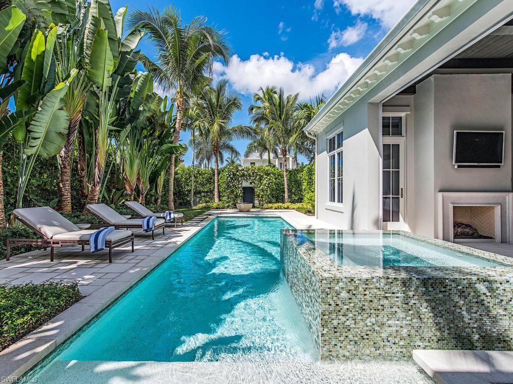 H.13574 Welcome to 272 5th Street North! This stunning home is a product of the highly-regarded Naples Redevelopment Team. Built in 2014, it boasts a two-story open floor plan with three bedrooms, a den, and three and a half baths. An exquisite kitchen with Thermador appliances, Quartz counters and Brookhaven Cabinetry all meld into a large, welcoming living area. All finished with custom designed handcrafted European oak wide plank flooring by Legno Bastone. The great room sliding glass doors pocket back to bring inside a lush and charming lanai complete with summer kitchen, outdoor fireplace and a truly inviting pool with integrated spa and glass tiled water wall feature. Tropical landscape,a fire bowl and romantic vined Arbor complete this outdoor living area. Though you will never tire of being in this home, step out the front door and the beach is five short blocks away and 5th Avenue is just seven blocks. The location, design, and construction of this home is what defines the Olde Naples lifestyle. Please click on the virtual tour link for a truly spectacular look into how this amazing home lives! Some exclusions apply.